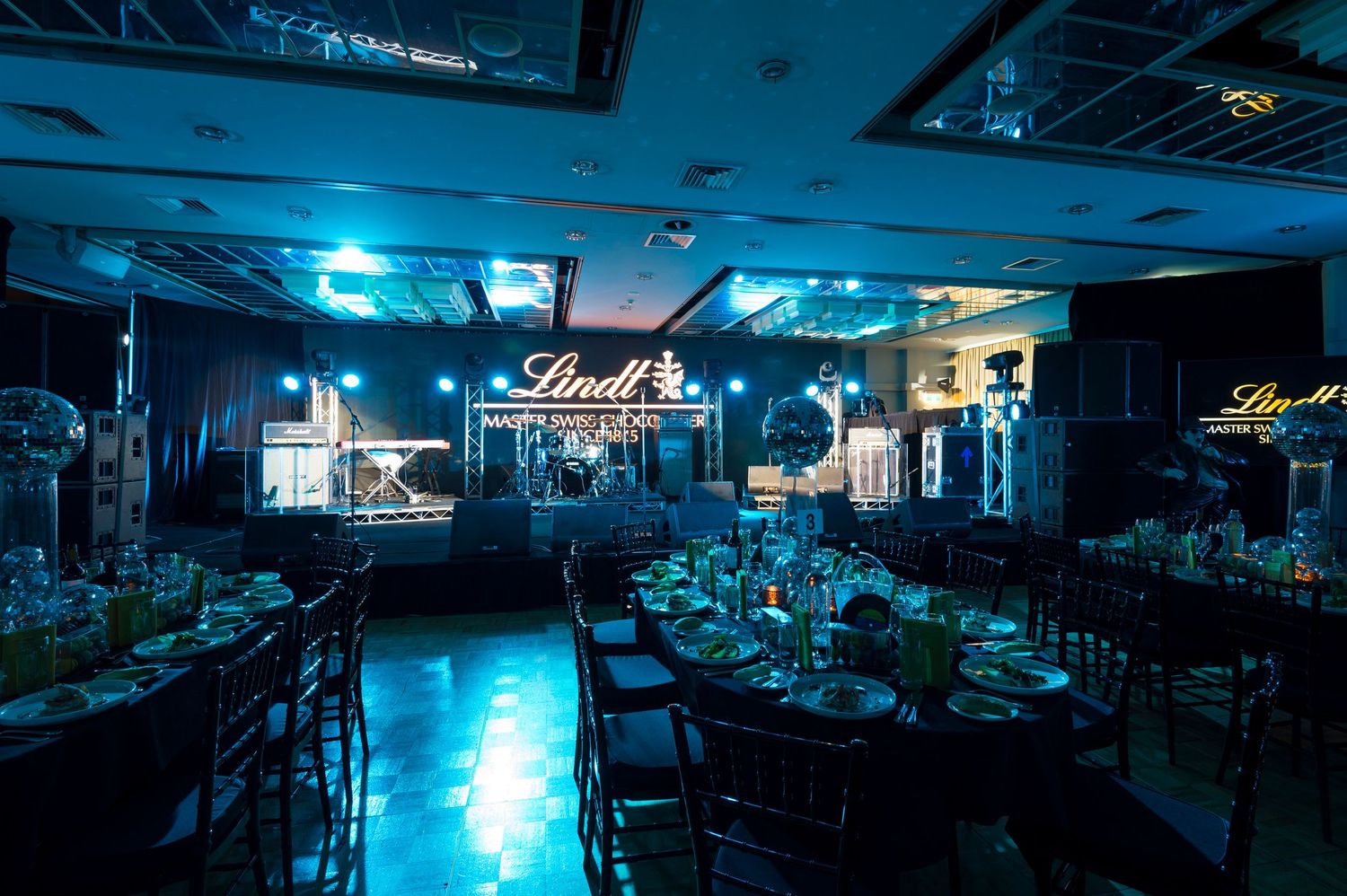 A series of dark arcade spaces illuminated by blue neon lighting creates a moody cyberpunk atmosphere.