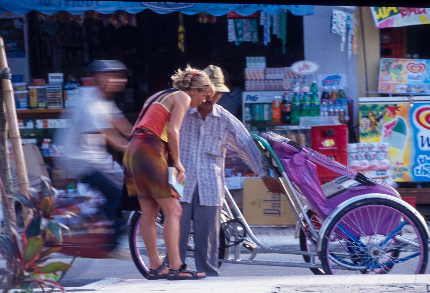 Blurred motion of people and bicycles on a busy city street.