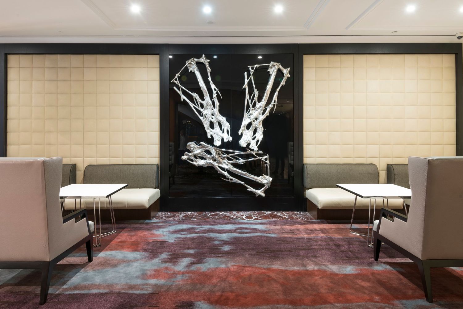 Contemporary dining room with dramatic black wall art and comfortable white seating arrangements.