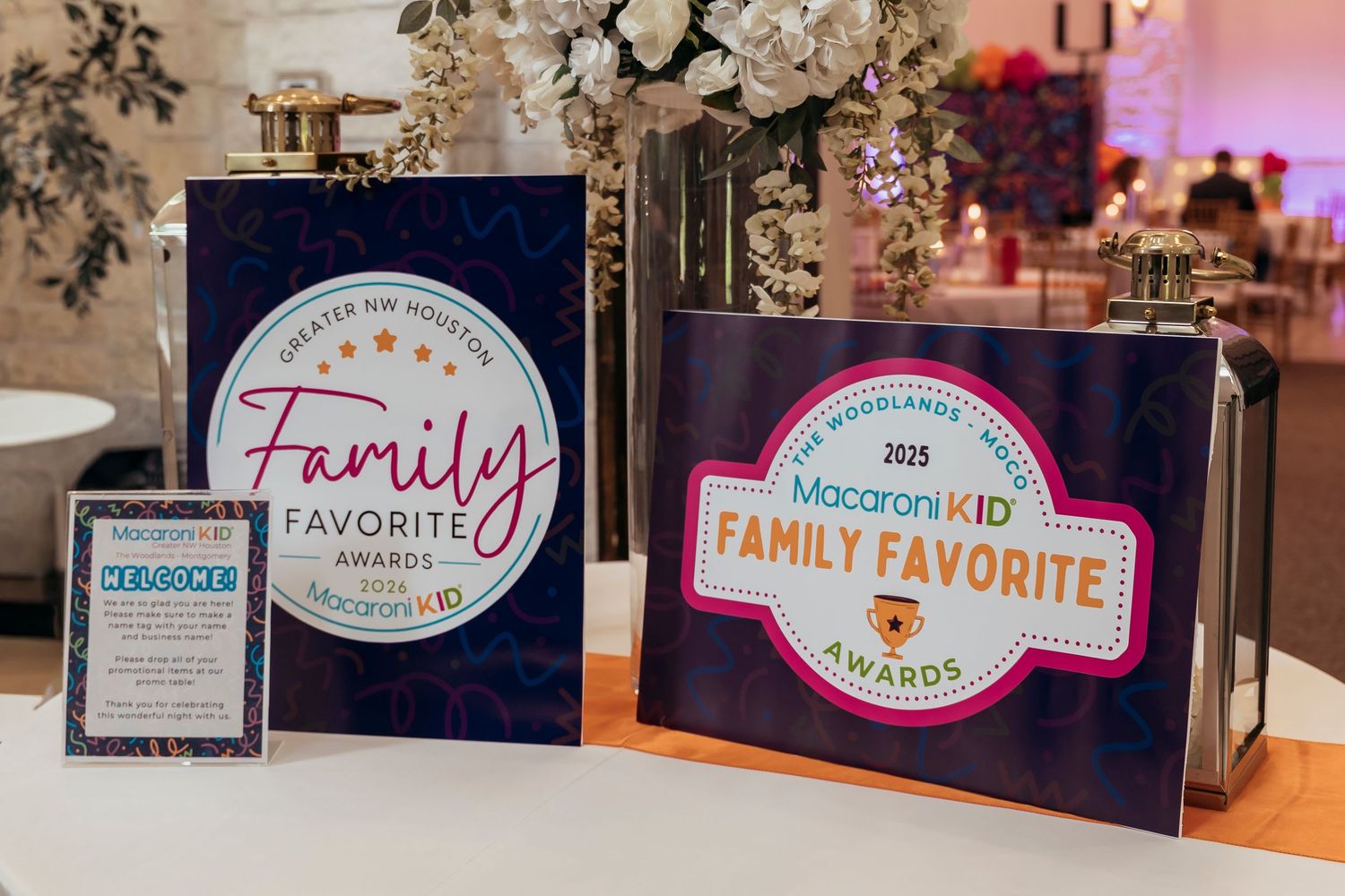 Two Macaroni KID Family Favorite Awards trophies displayed on a table at an elegant event venue.