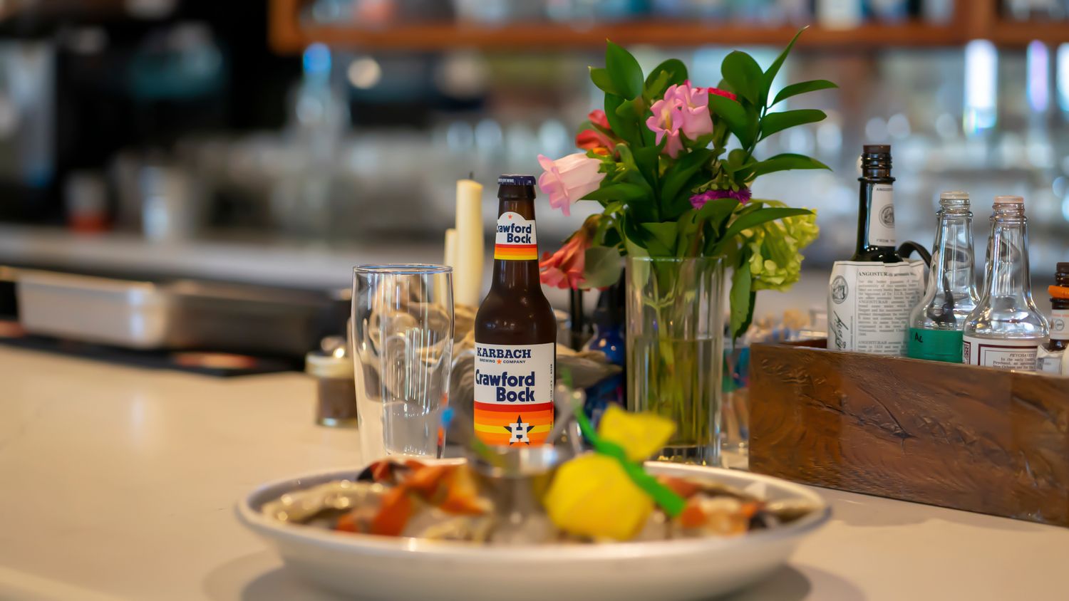 Oyster platter with Crawford Bock beer and fresh flowers displayed on a restaurant bar.