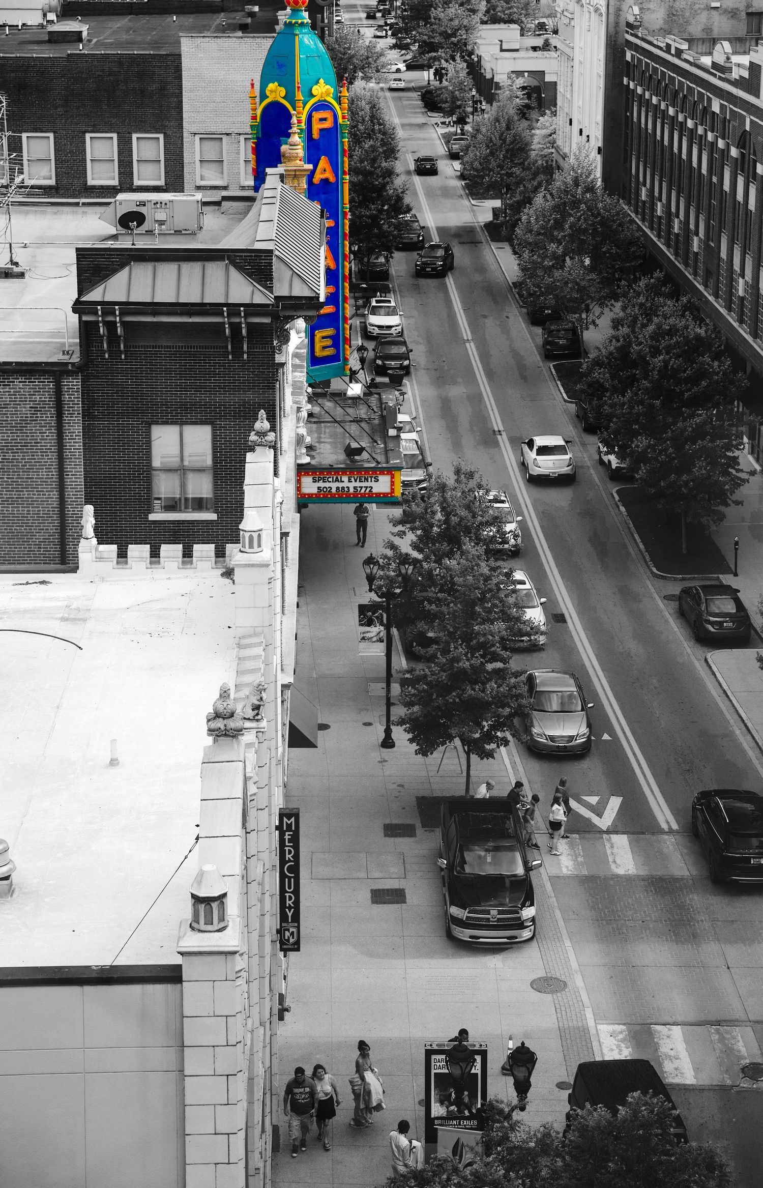 Aerial view of downtown Louisville with the iconic Palace Theatre marquee in color against a black-and-white city street scene.