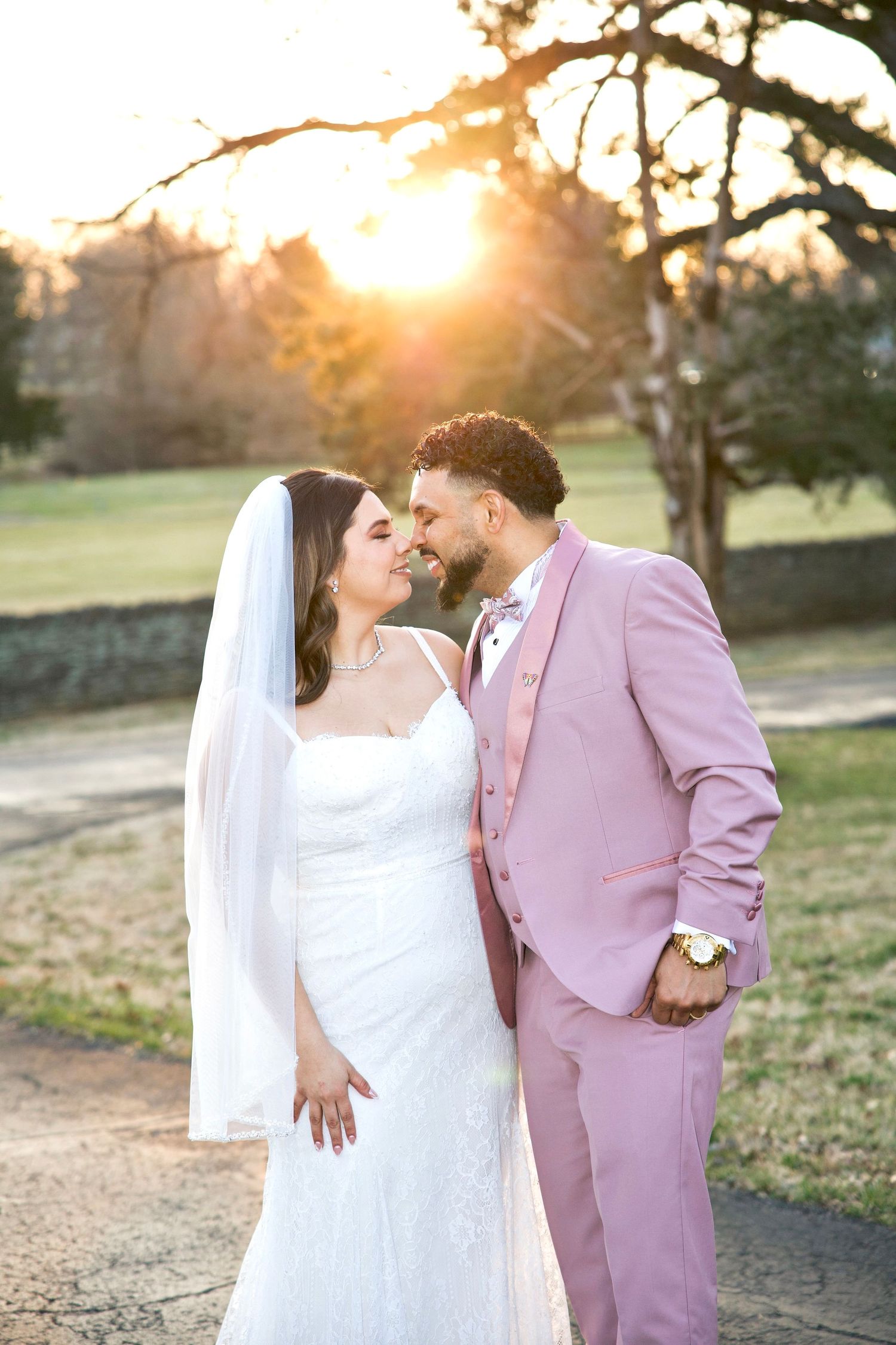 Bride and groom smile at each other during a sunset wedding portrait outdoors.