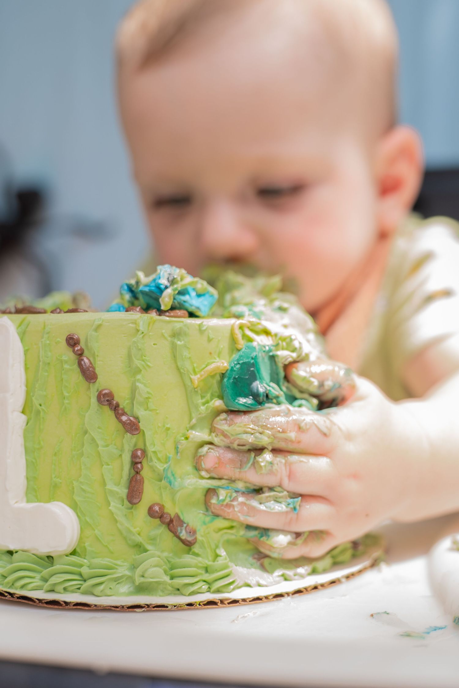 Toddler holding birthday cake with a 1 on it