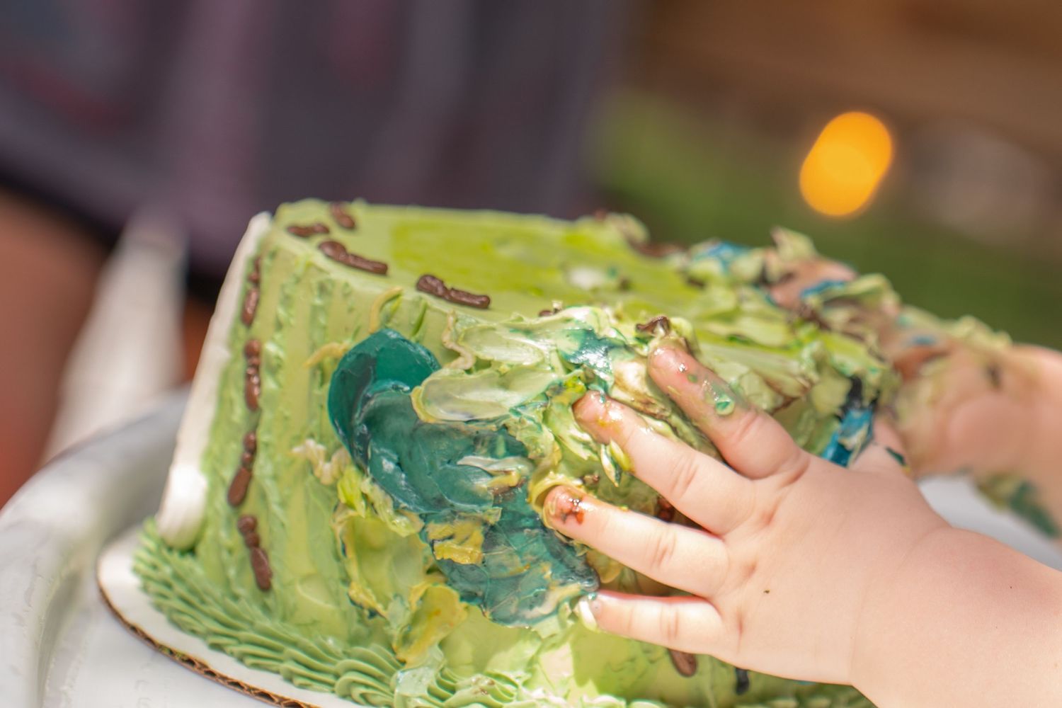 Close up of toddlers hands on cake