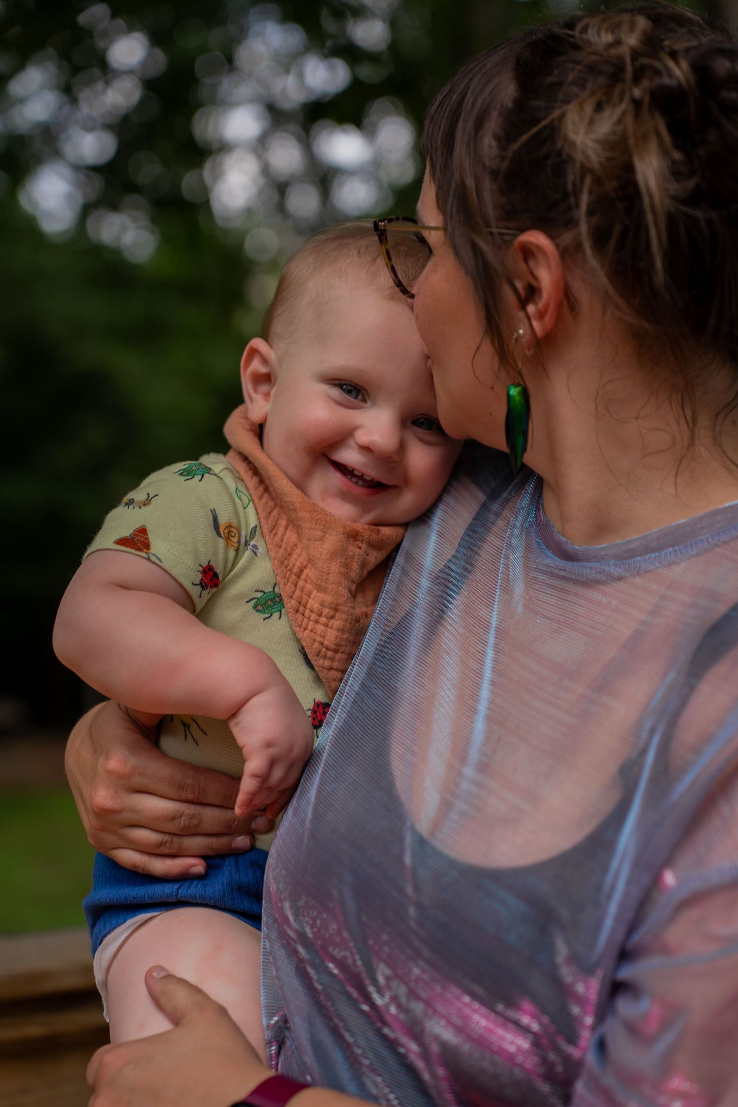 Toddler smiling while cuddling mum