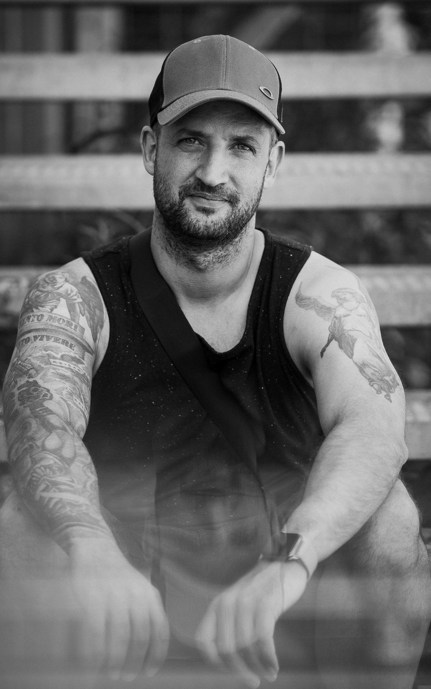 Black and white portrait series showing a man in a baseball cap with tattoos.