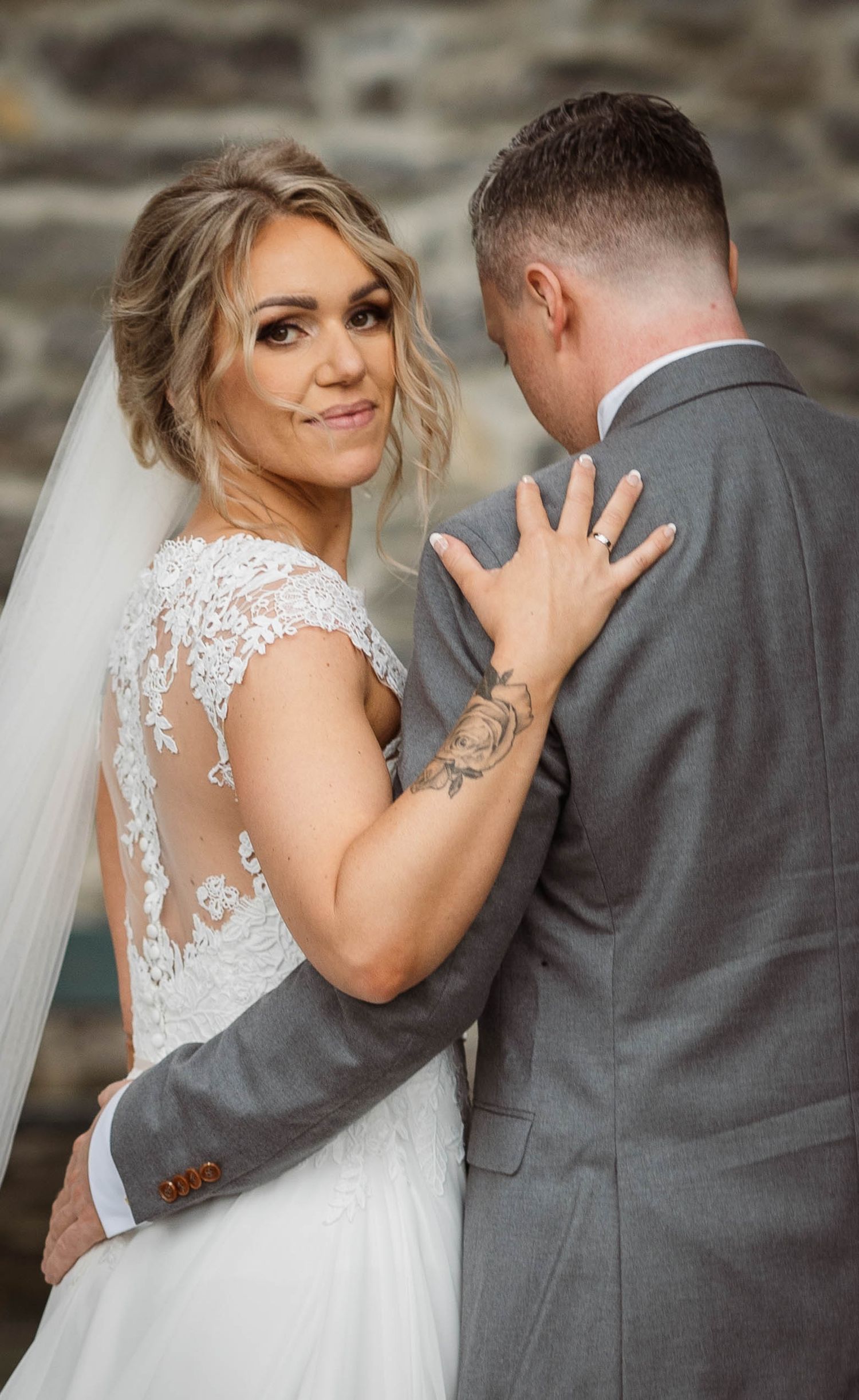 Wedding couple in white dress and grey suit share intimate moments during outdoor photo session.
