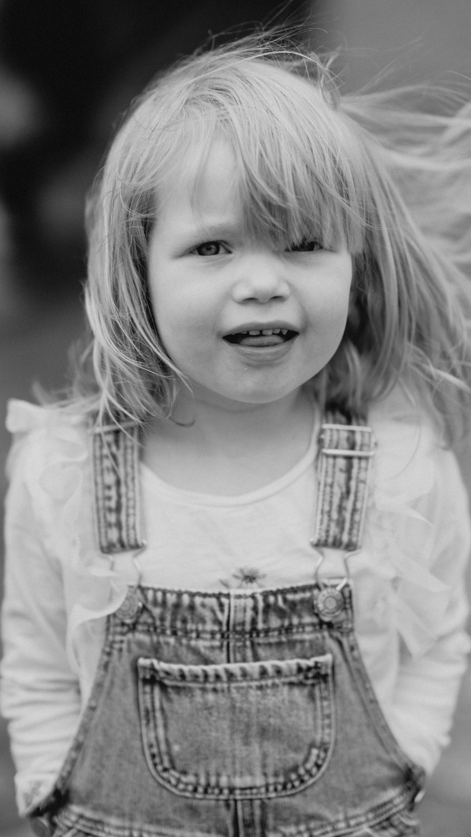Black and white portrait series showing denim overalls and white shirt outfit.