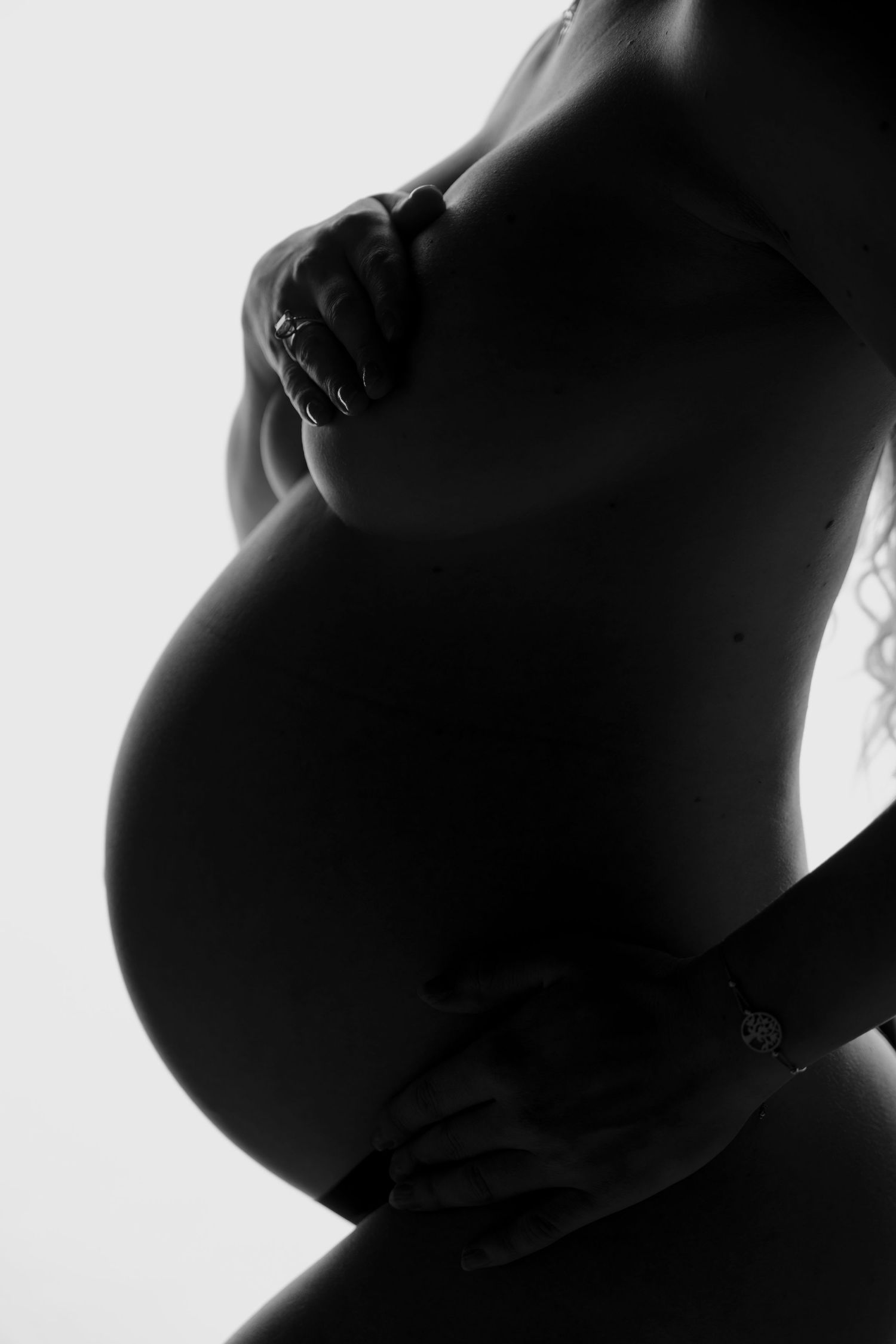 Artistic black and white pregnancy photos with dramatic lighting and shadows.
