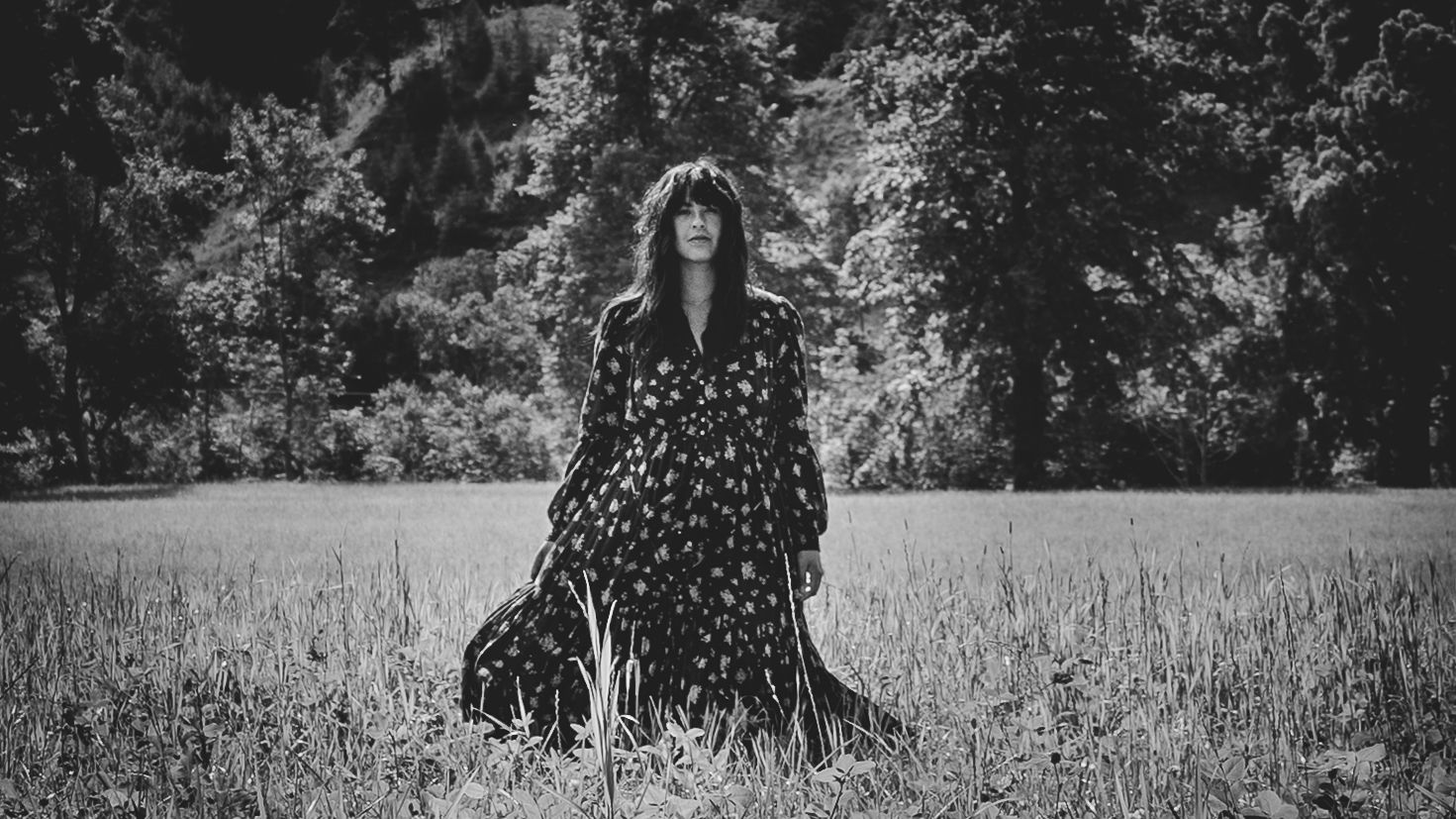 Black and white outdoor scene with polka dot dress in a field.