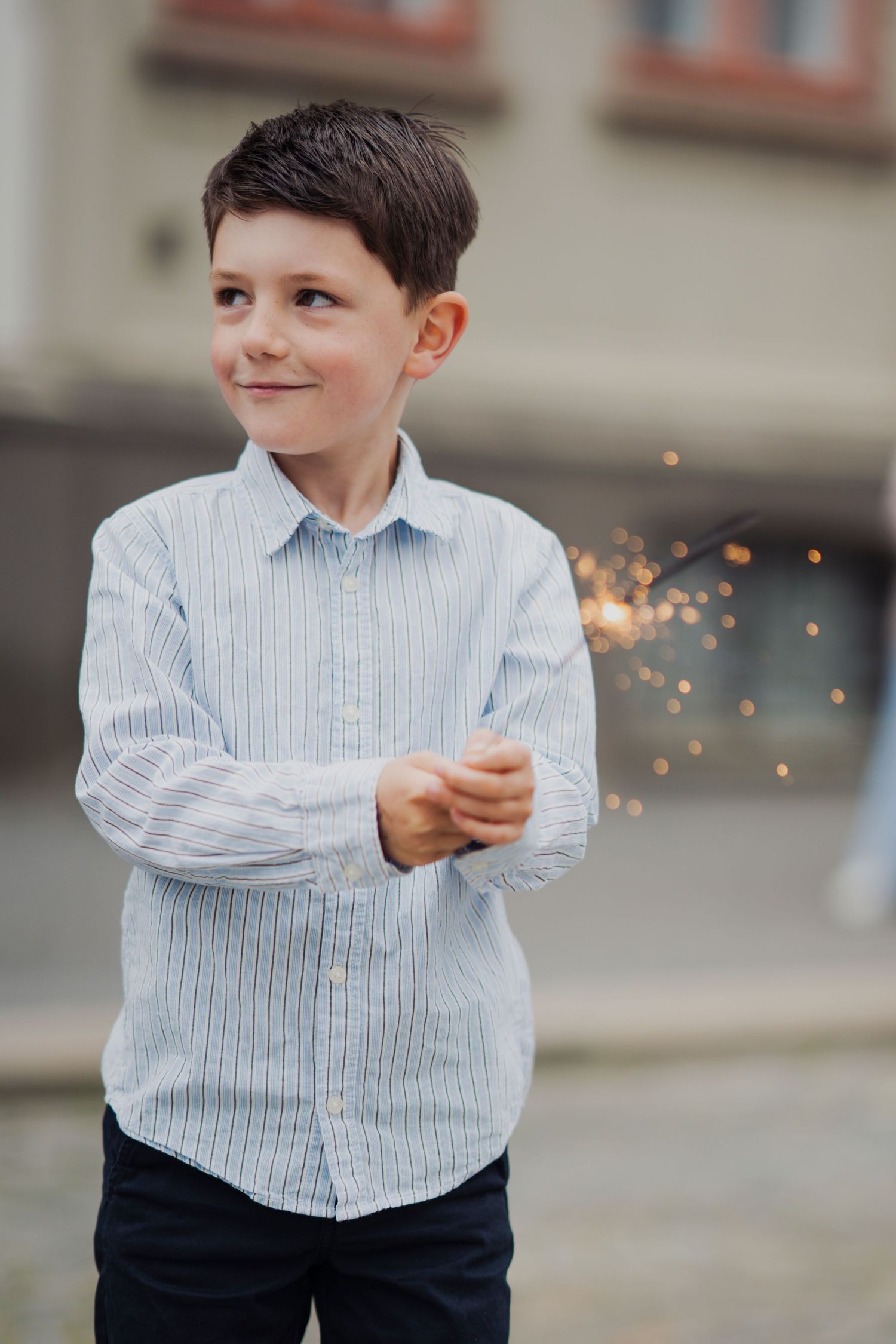 Sequence showing sparkler creating light trails against urban background.
