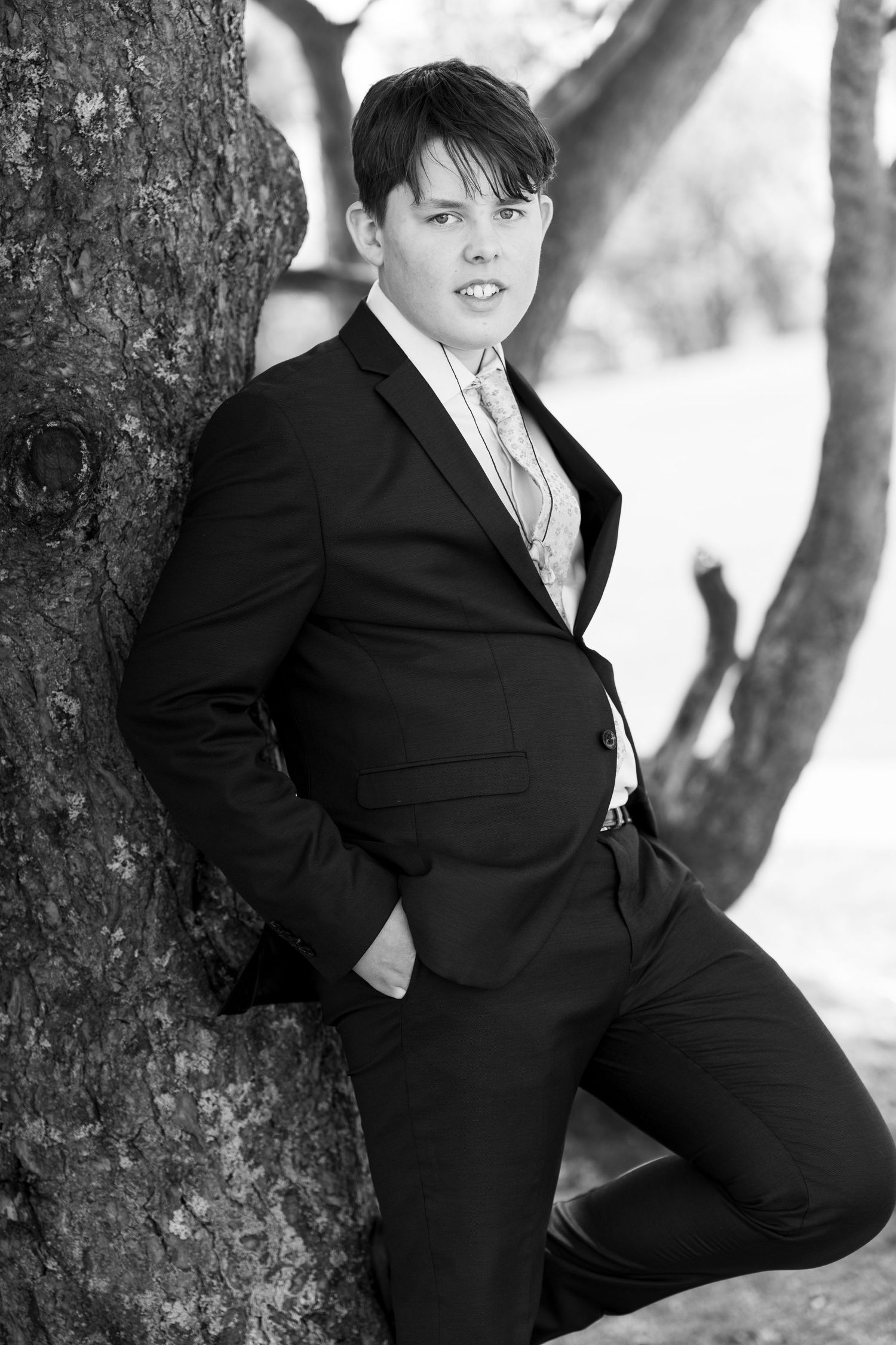 Black and white formal portraits taken against a tree trunk in winter.