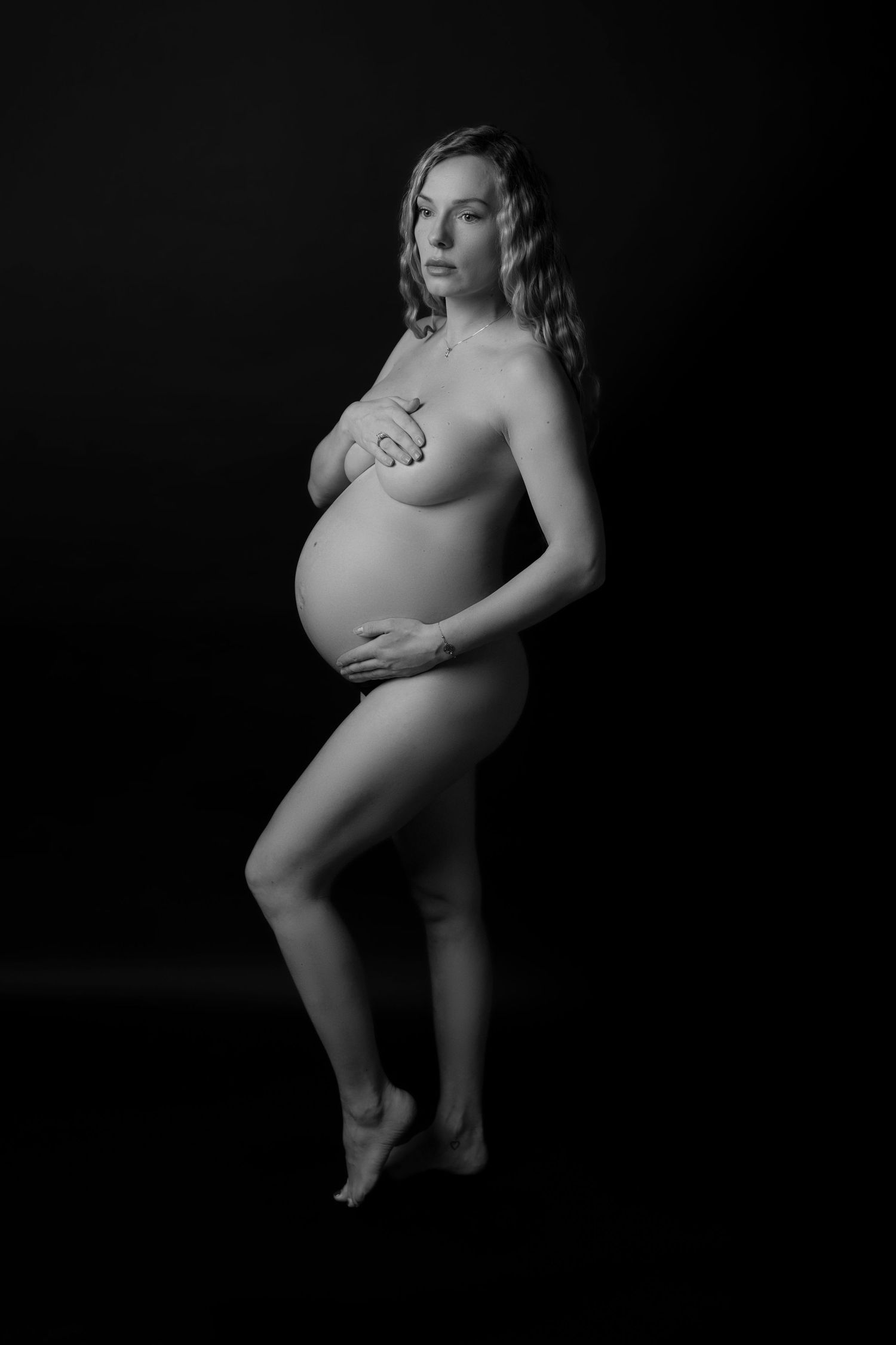 Artistic maternity silhouette showing pregnancy curves in black and white.