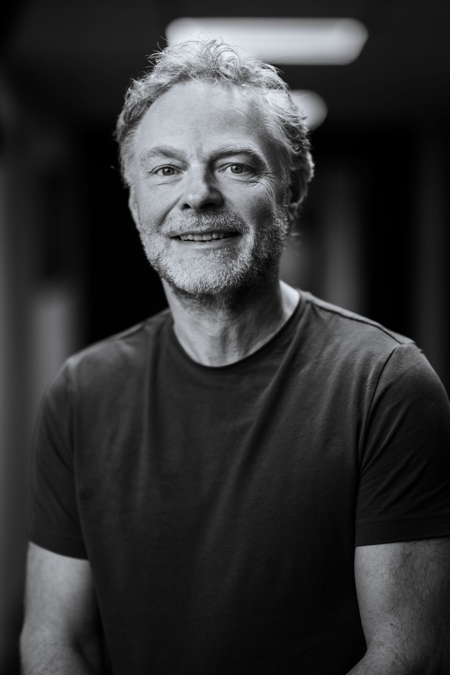 Dramatic black and white headshot with natural lighting and expression.