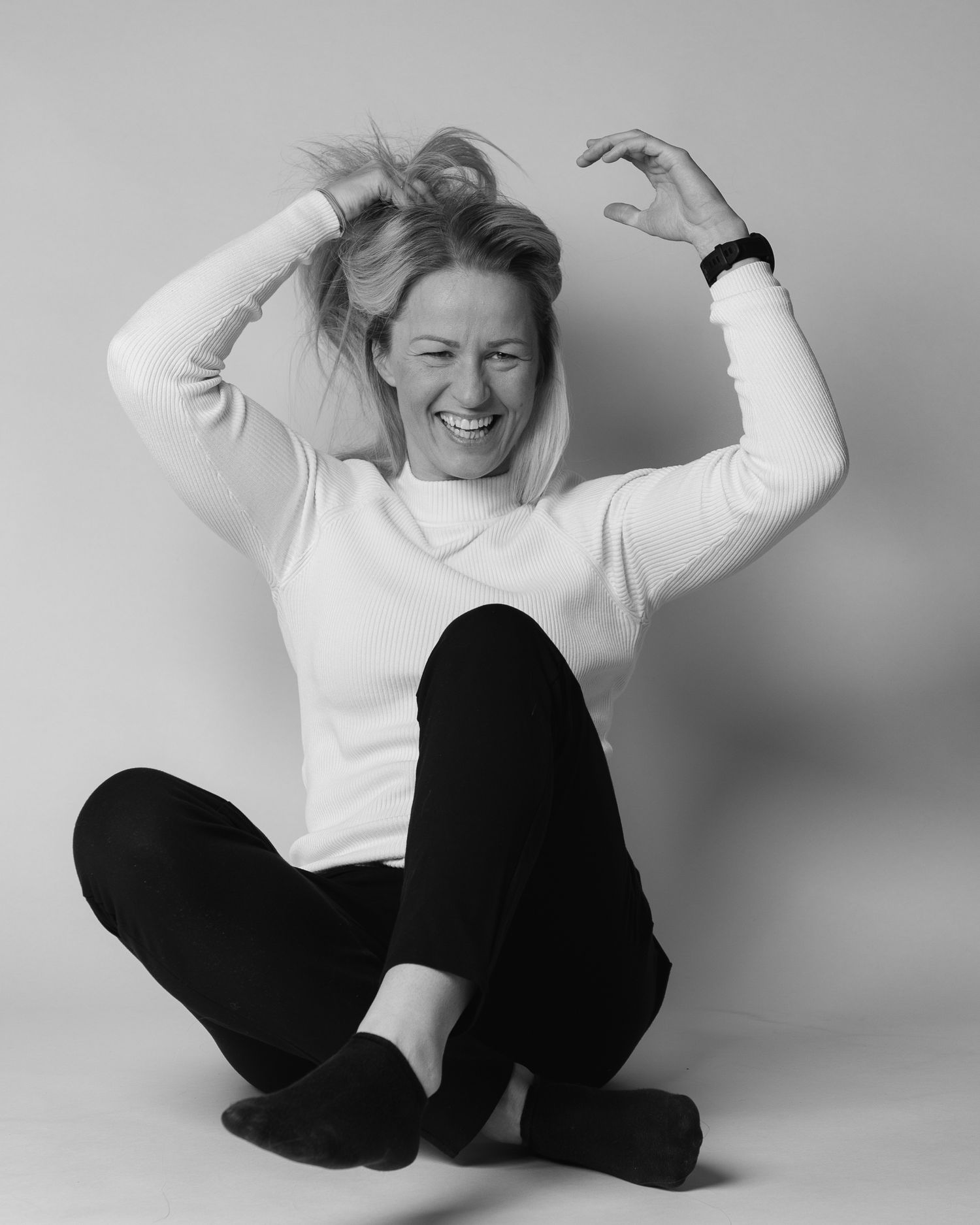 Person in white sweater and black pants expressing joy through dynamic movement poses.