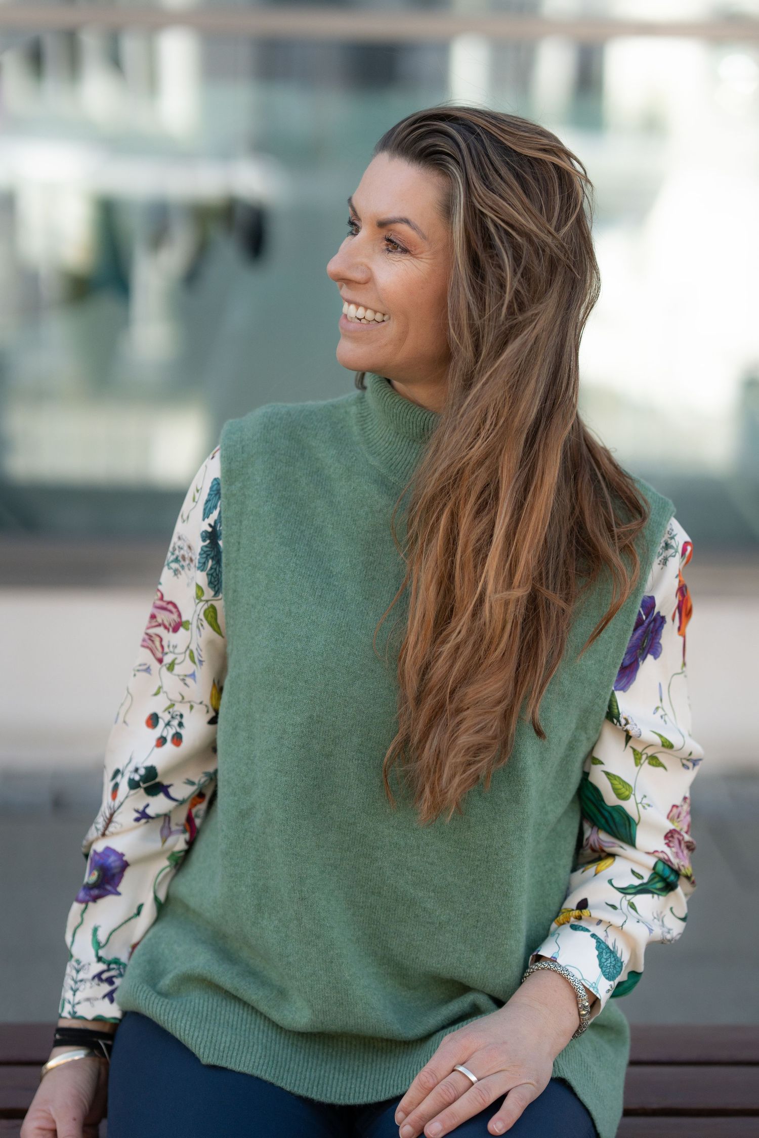 Green sweater with floral print sleeves shown in casual office setting.
