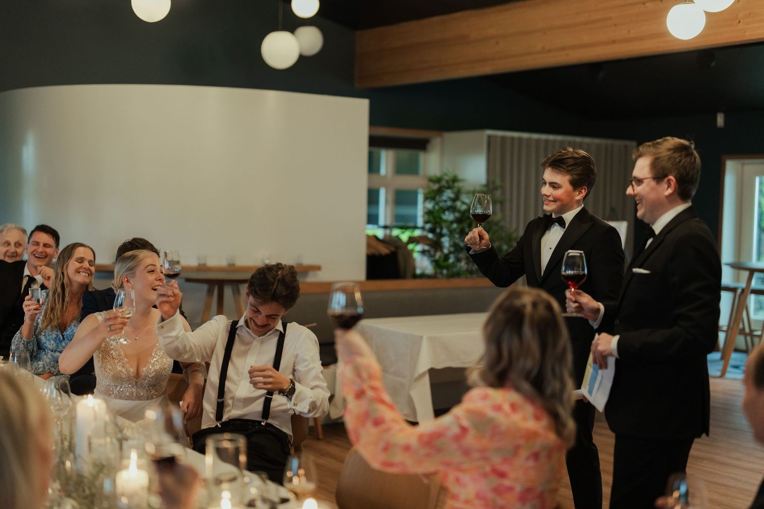 Panoramic view of a wedding celebration with guests seated at decorated tables.
