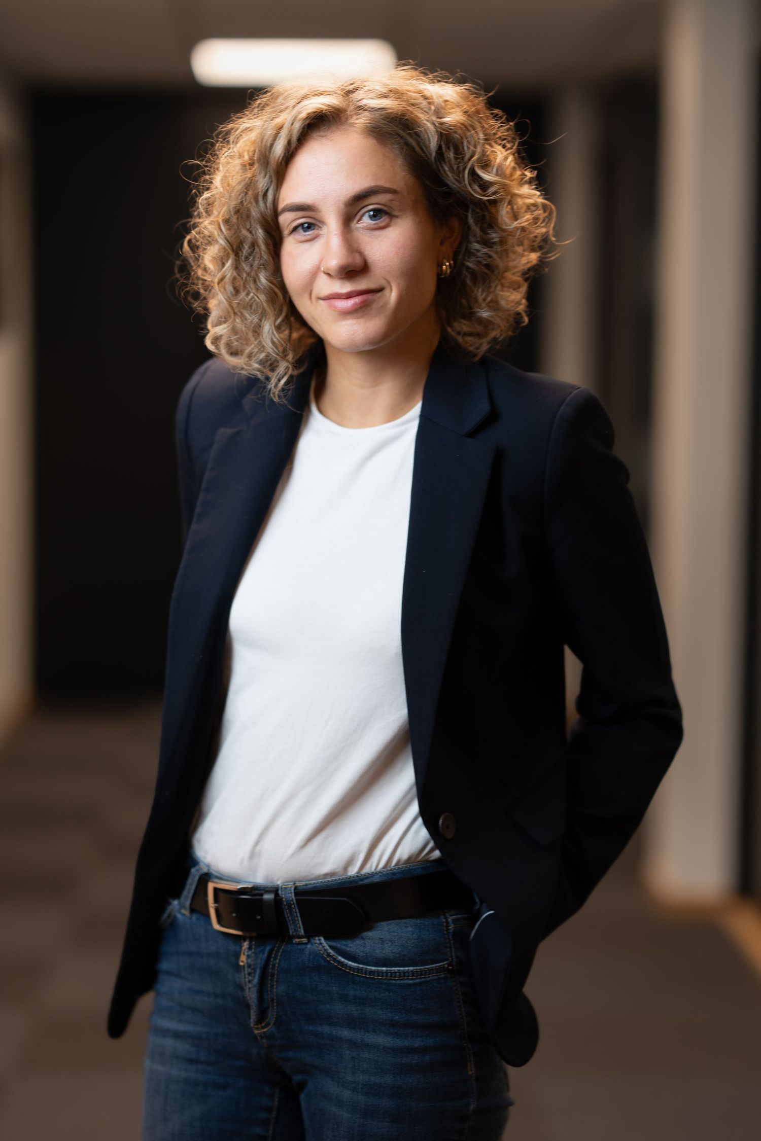 Professional portrait showing business attire with a navy blazer and white top.