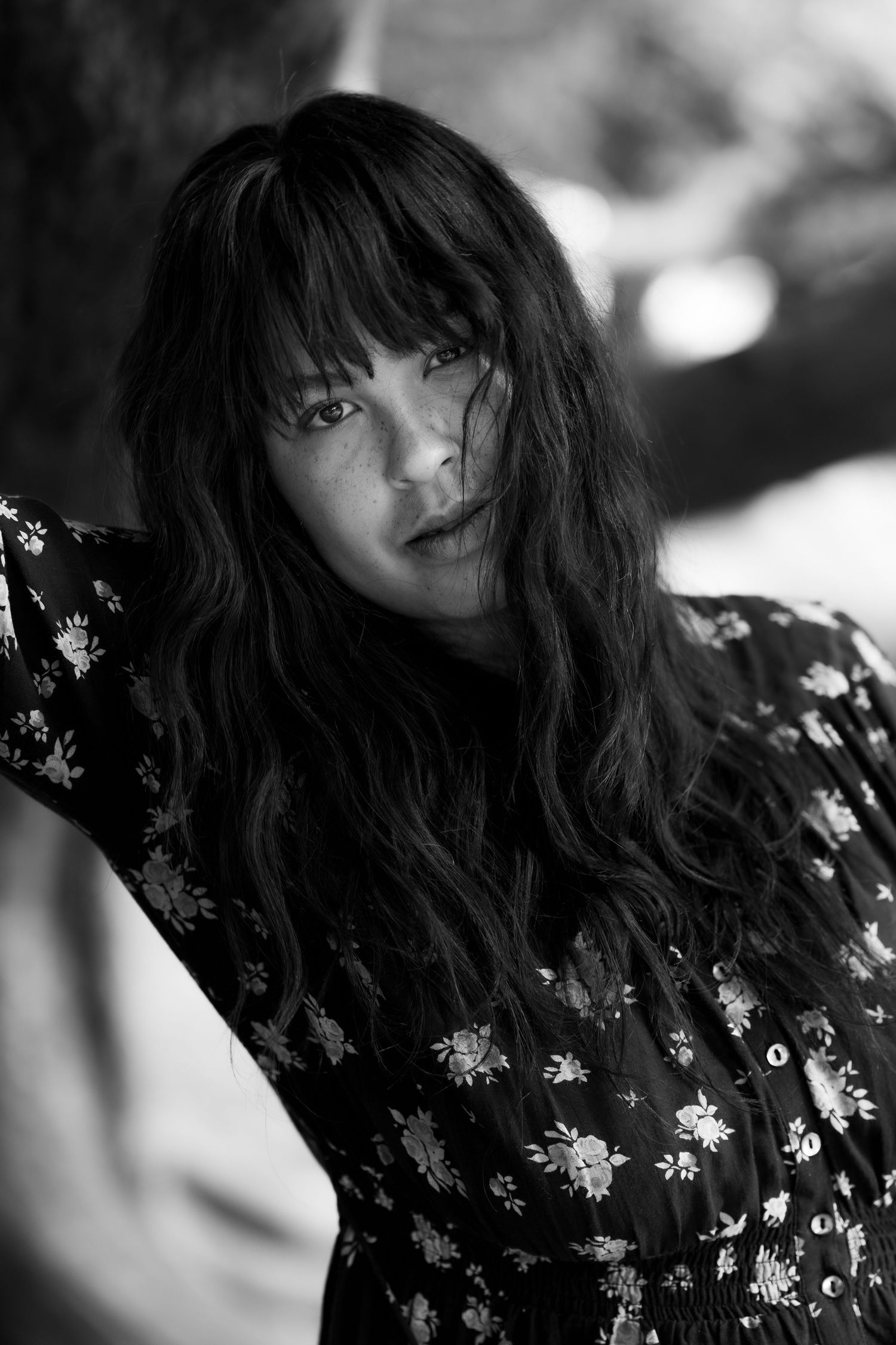 Close-up black and white portraits showcasing dark hair and a patterned top with natural lighting.