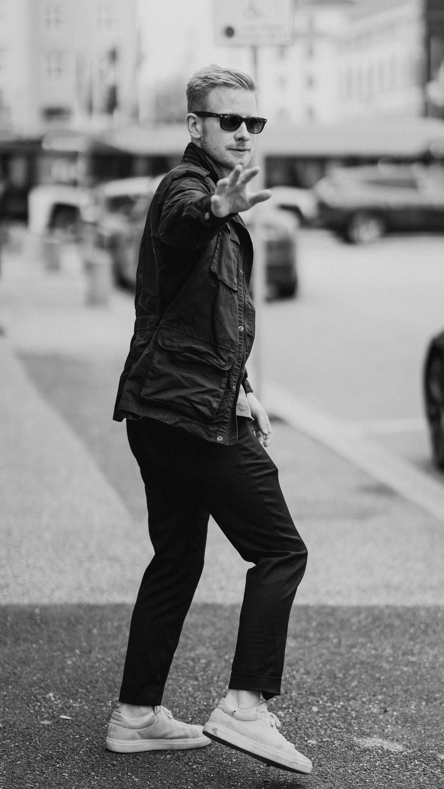 Black and white sequence showing stylish poses on urban street setting.
