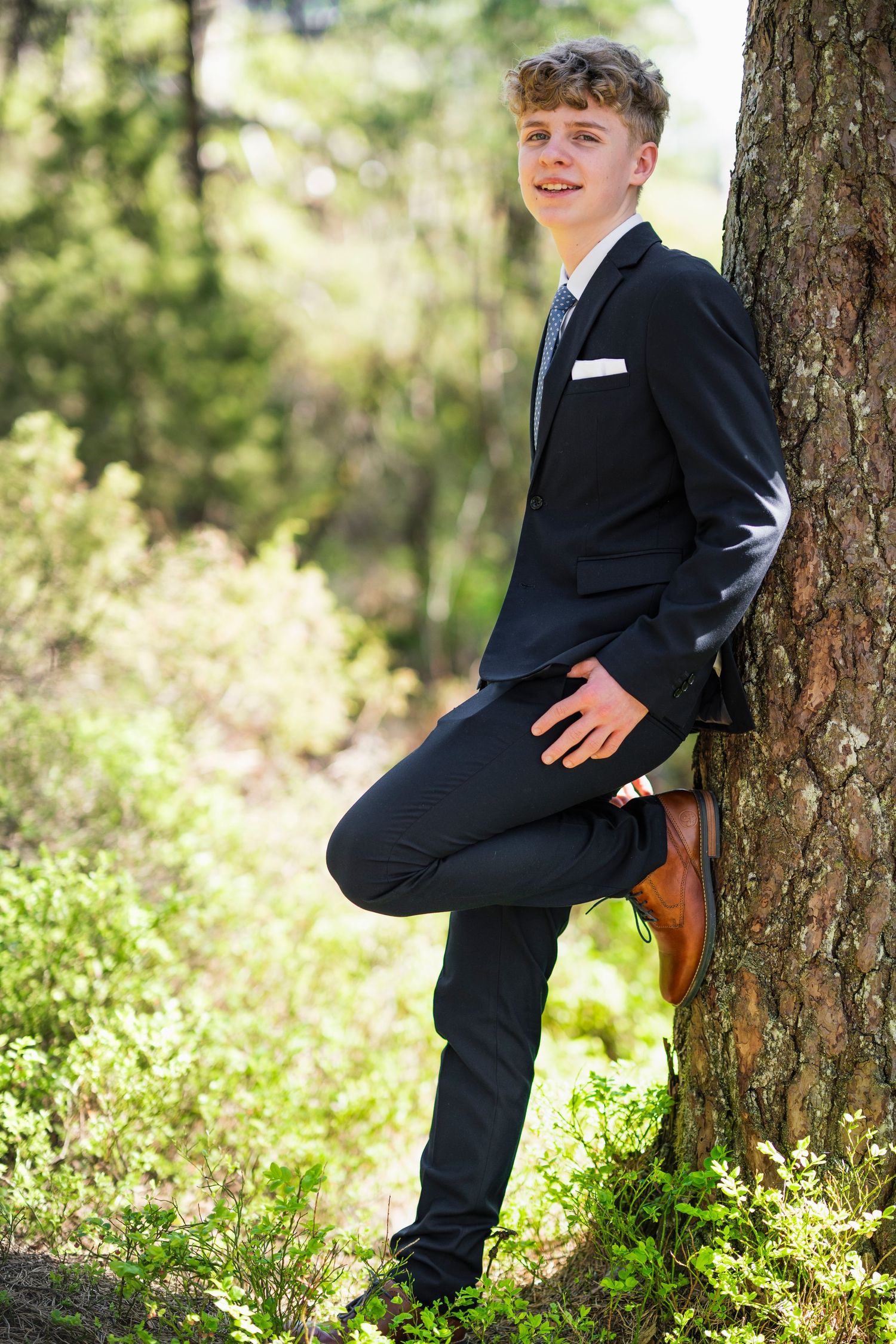 Playful outdoor portraits showing poses against tree trunk in nature setting.