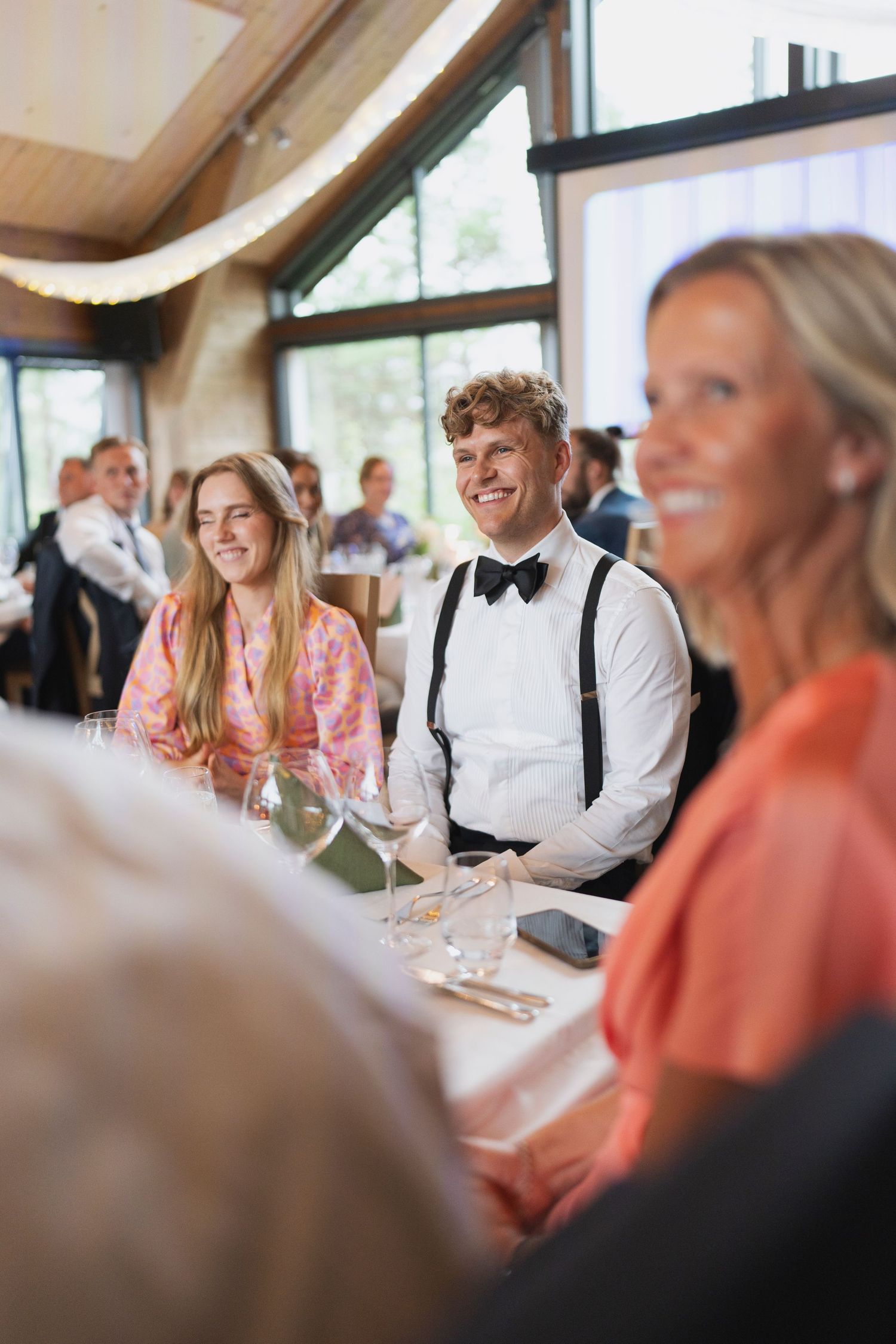 Wedding guests enjoying dinner and conversation at elegantly set tables.