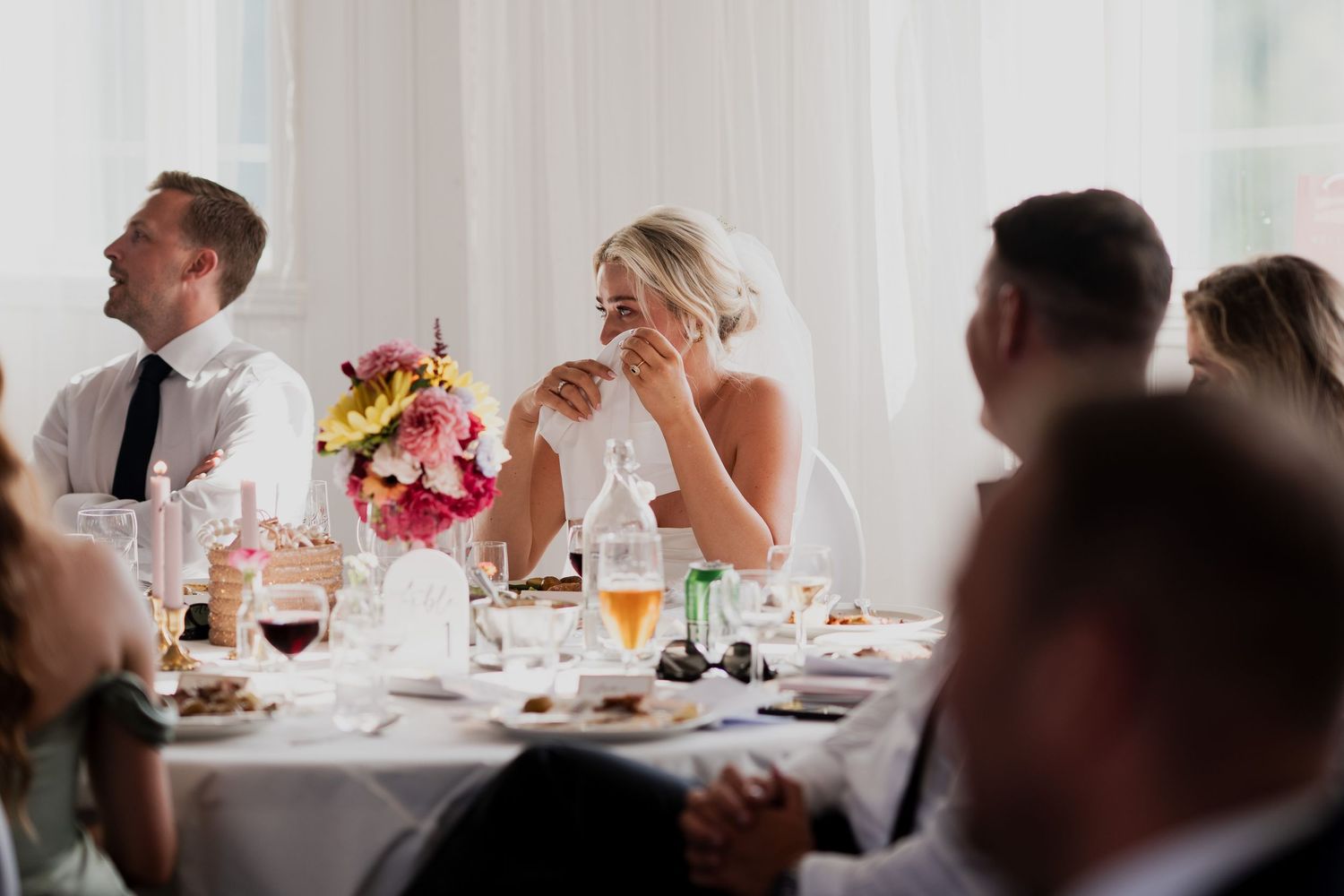 Wedding reception dining room with white tablecloths and place settings.