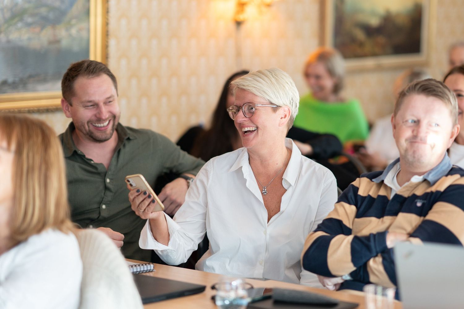 People sitting at tables during casual business meeting or workshop.