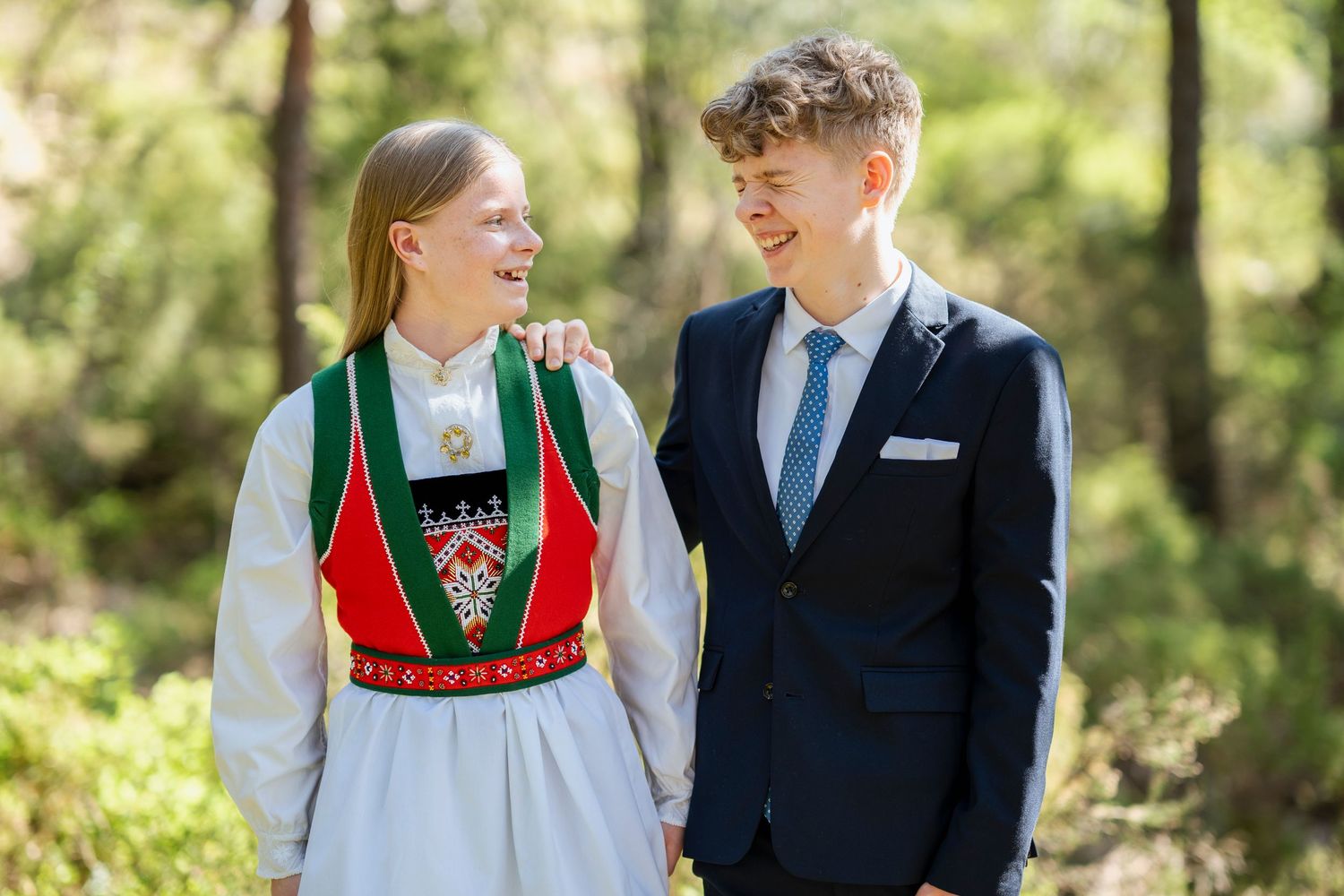 Outdoor portrait featuring traditional Norwegian folk dress and formal wear.