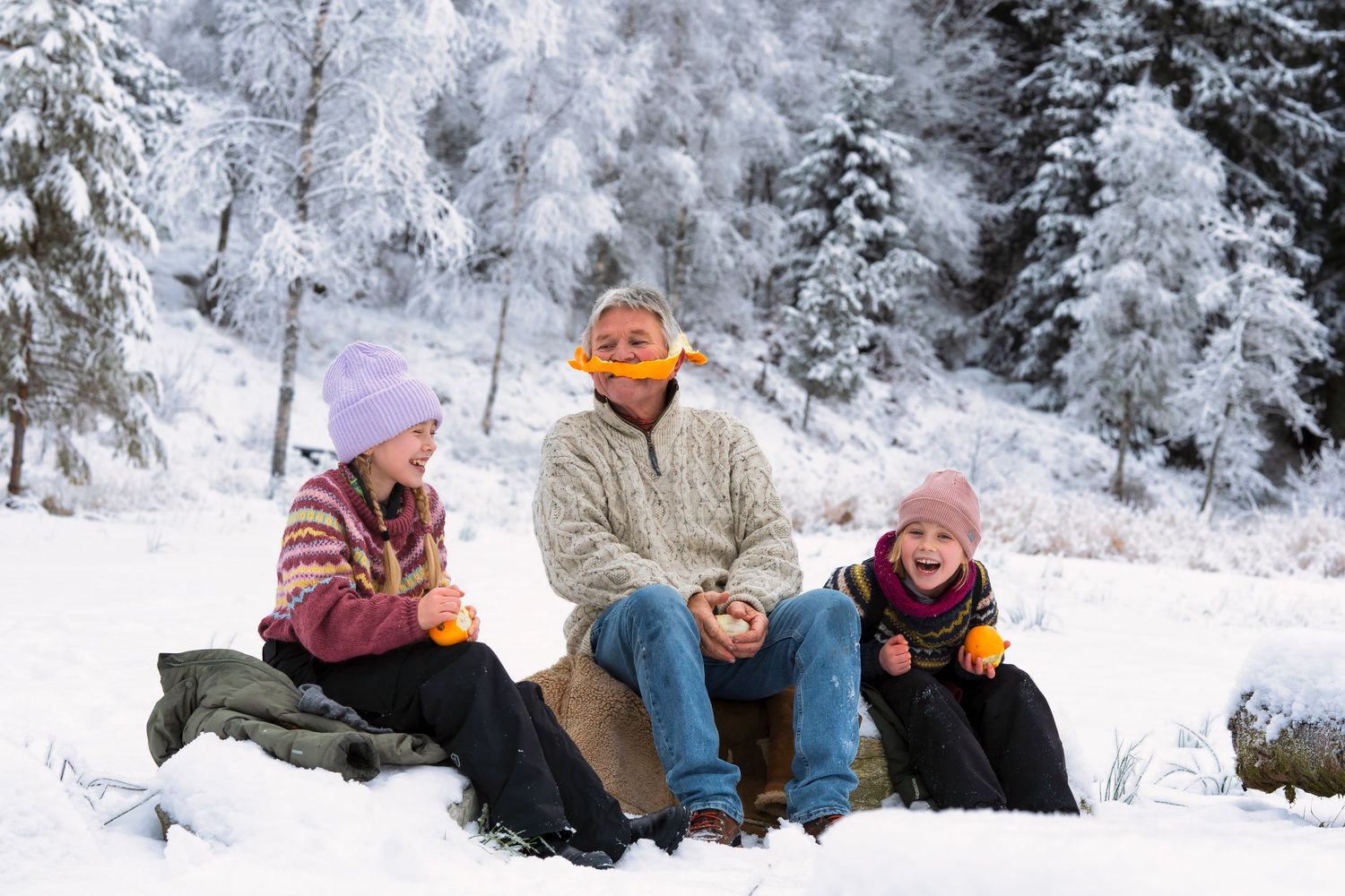 Snow-covered winter landscape with people enjoying outdoor activities.