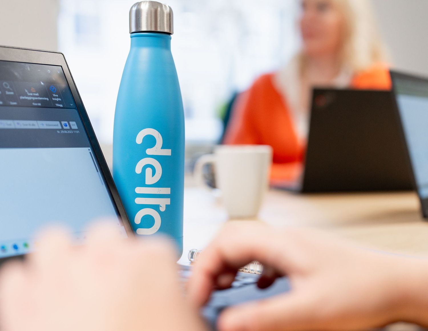 Blue water bottles sit on a desk in an office setting.