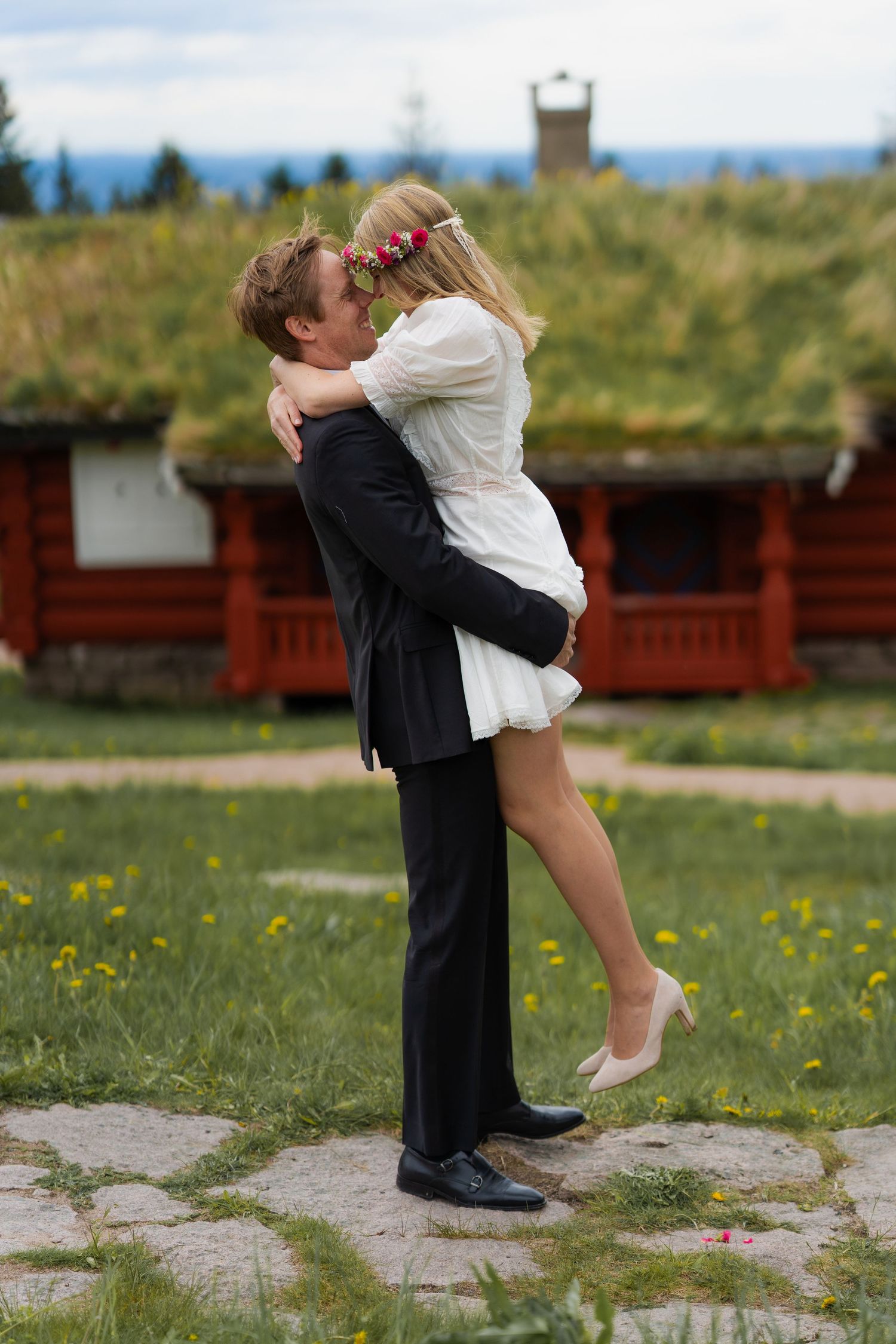 Romantic couple in formal wear sharing a playful moment outdoors.