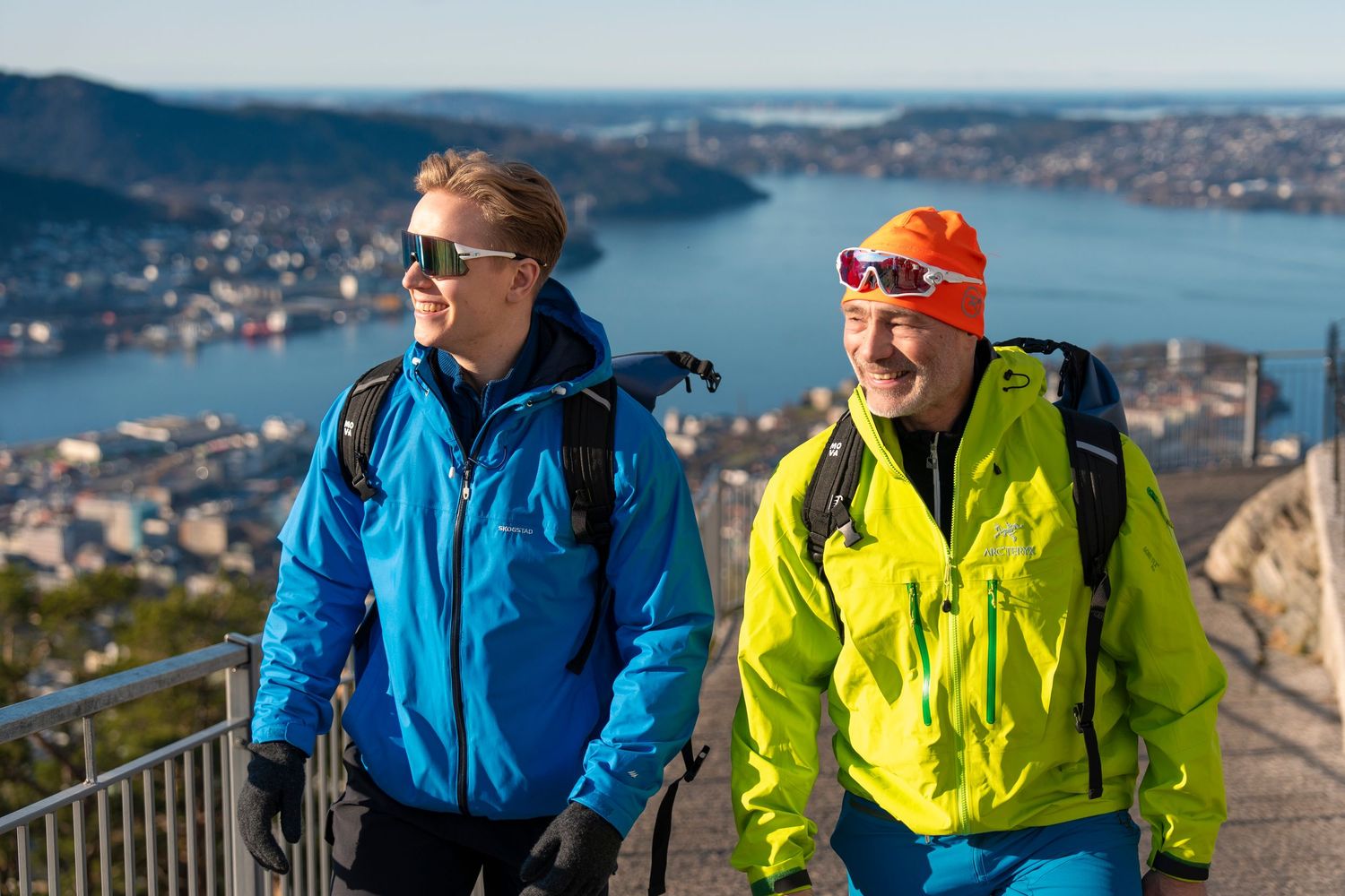 Hikers in bright blue and yellow jackets enjoying scenic mountain vista.
