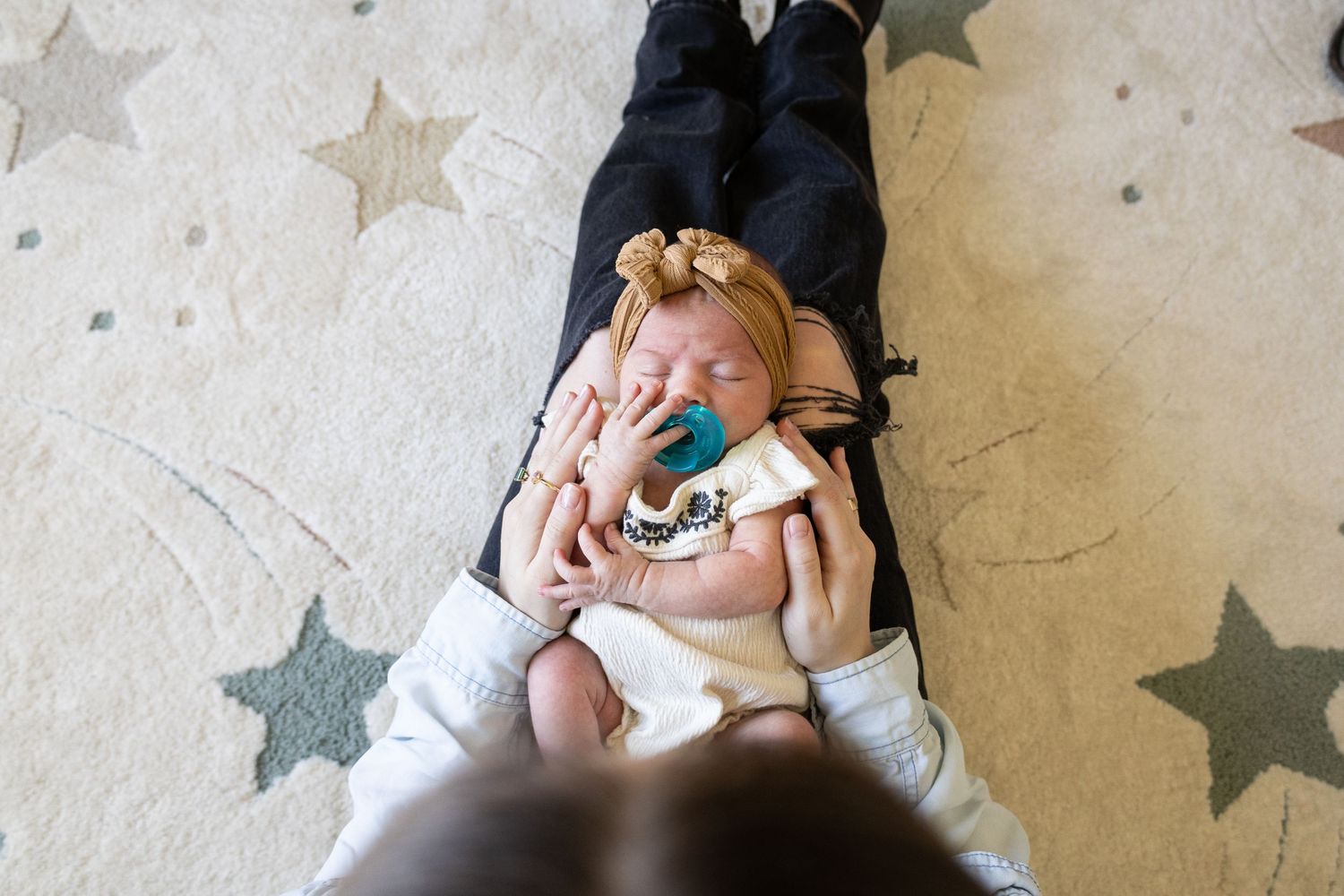 Parent holding a sleeping newborn during an in-home lifestyle newborn photography session in North Alabama.