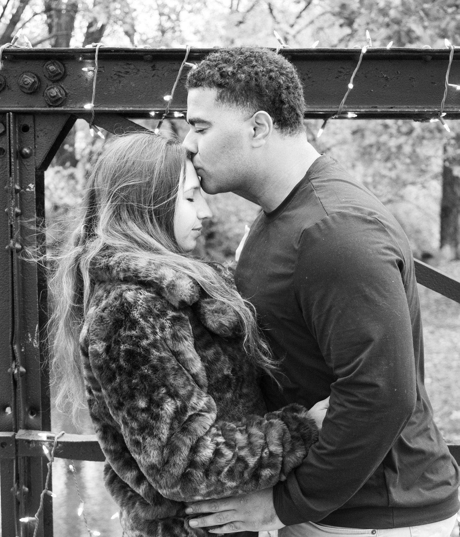 A series of black and white romantic photos showing tender moments between a couple outdoors.