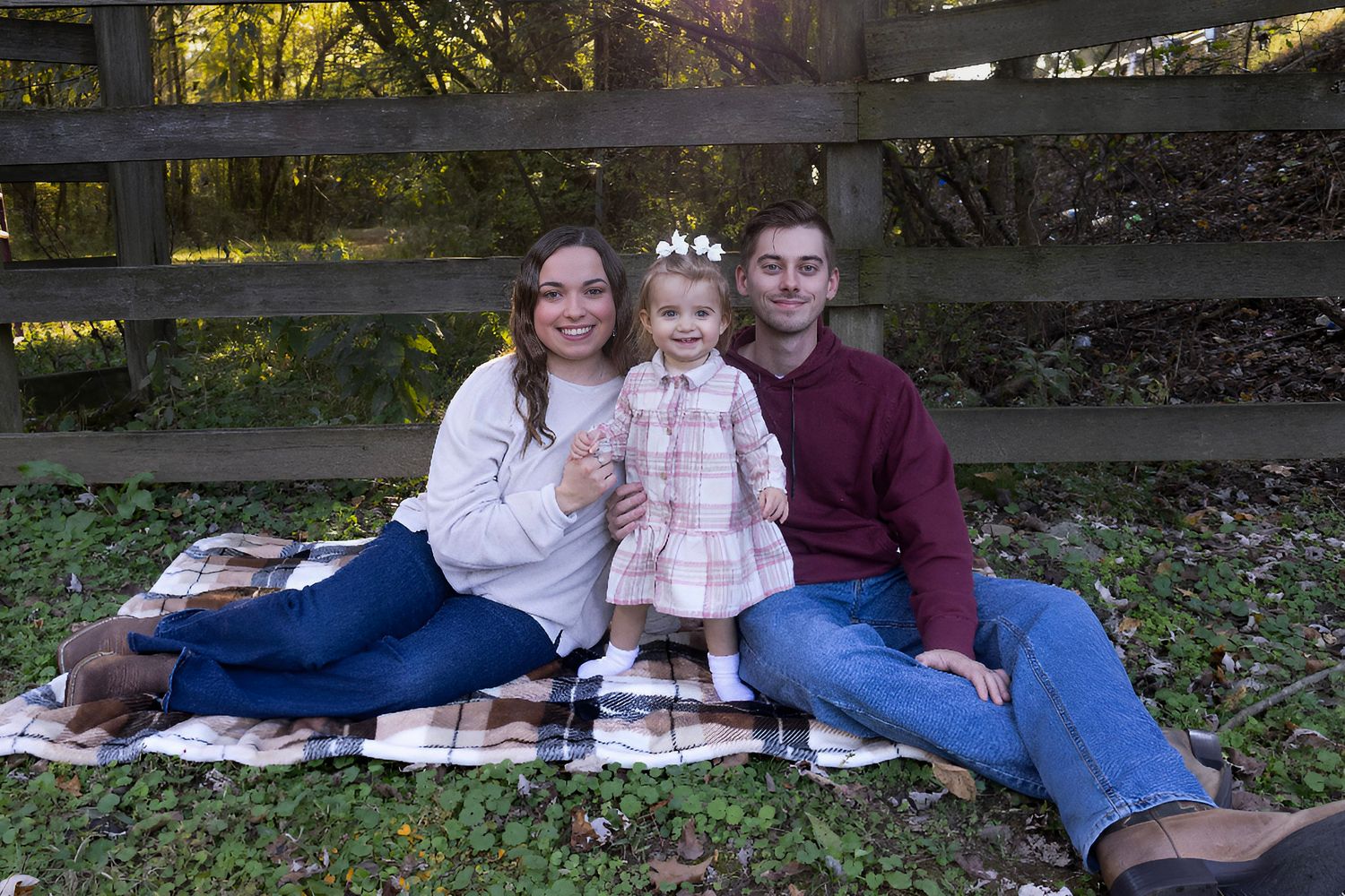 A family lounging on a blanket during an outdoor photo session in a park.