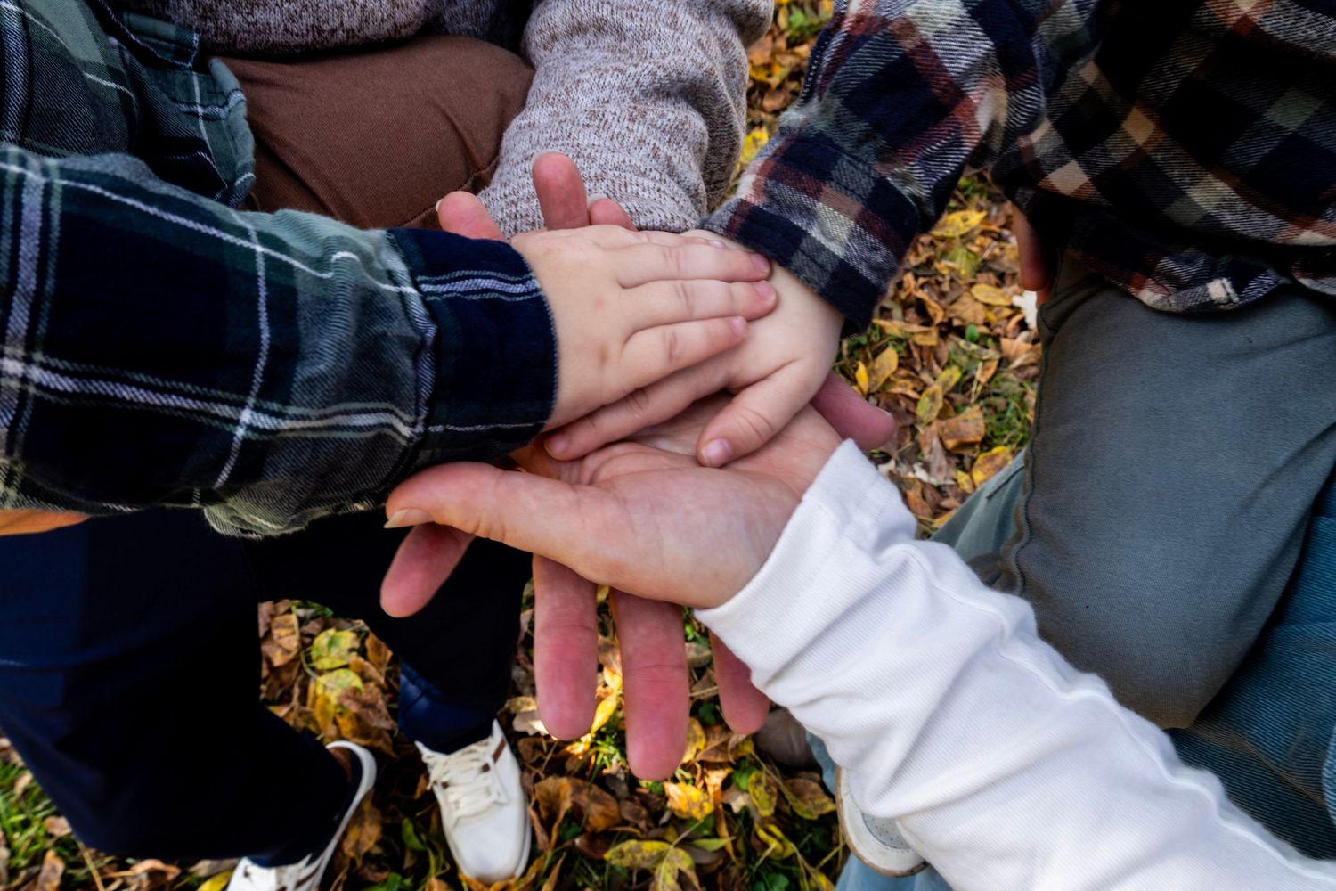 A family enjoying a relaxed outdoor photoshoot together on a blanket in autumn.