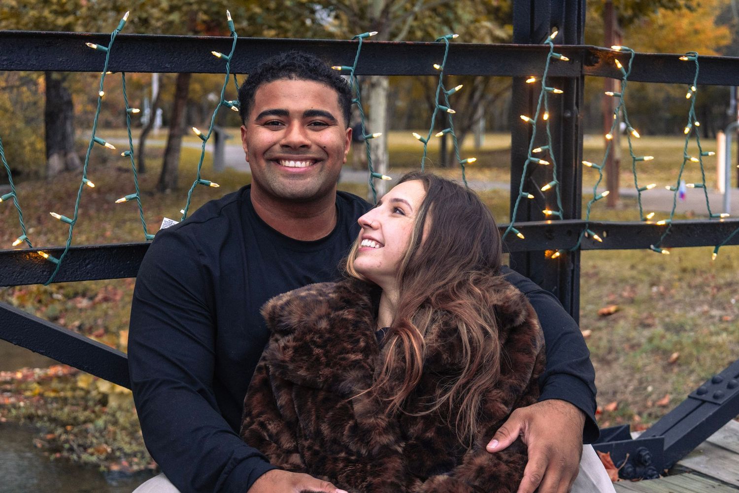 Joyful engagement photo session in a park during autumn season.