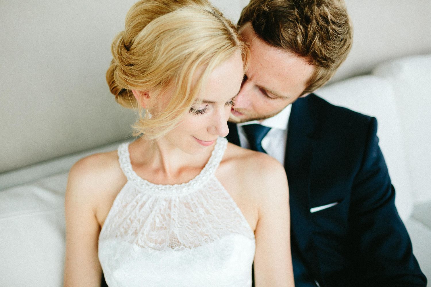 Romantic close-up of bride and groom sharing intimate moment in soft natural light.