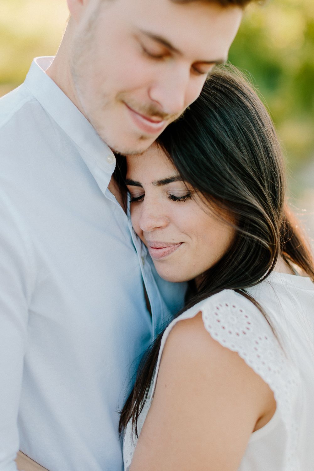 Close-up of a couple sharing a tender embrace with soft natural lighting.