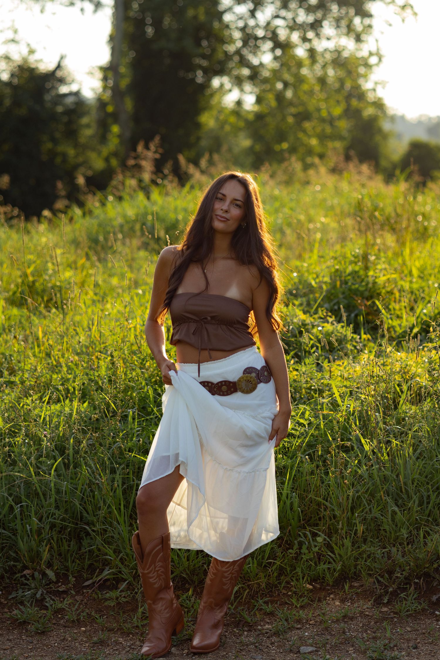 Outdoor portrait in brown top and white skirt with cowboy boots during golden hour in Wilmington, Delaware.