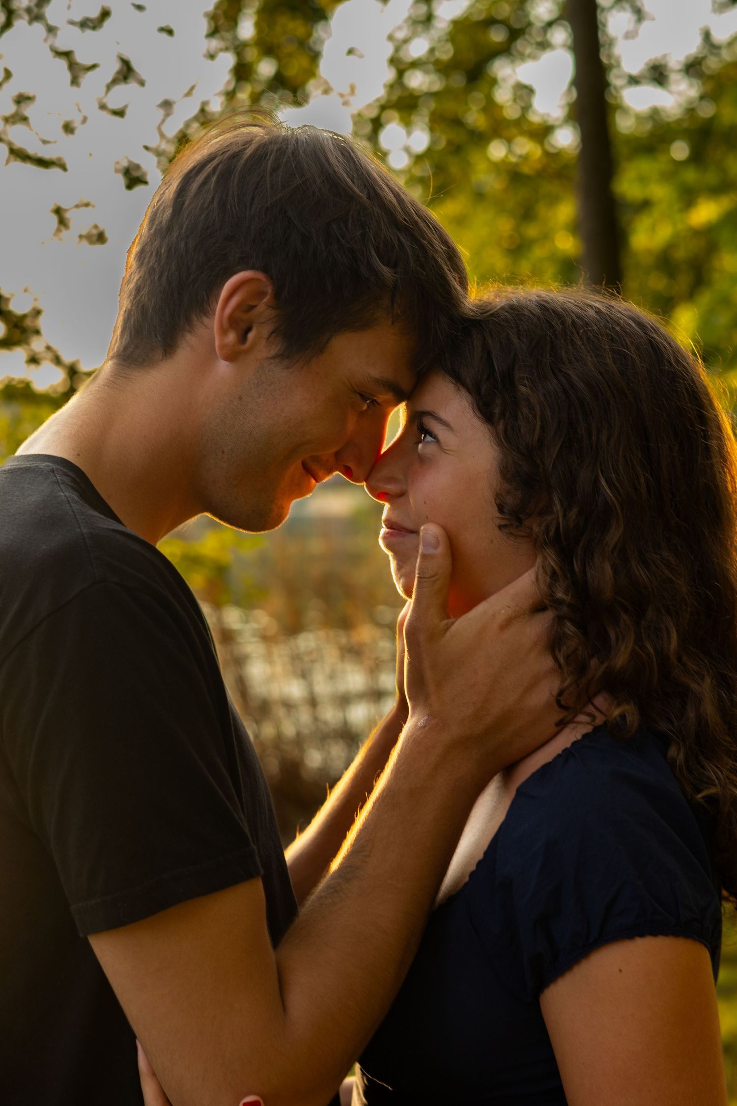 A tender sunset moment captured between two people in a natural outdoor setting in Bear, Delaware.