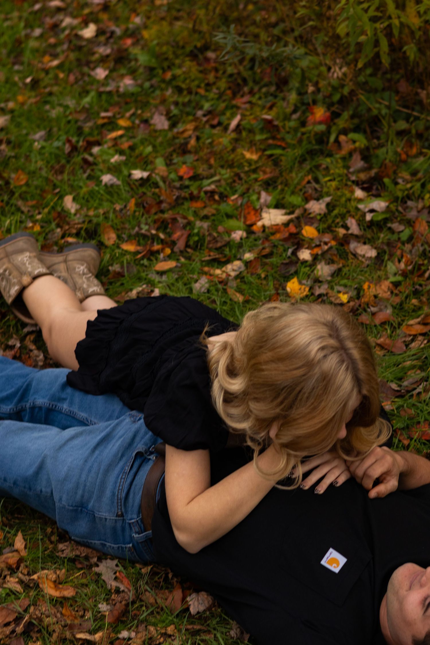 Couple lying in autumn leaves during an outdoor photo session in Newark, Delaware.