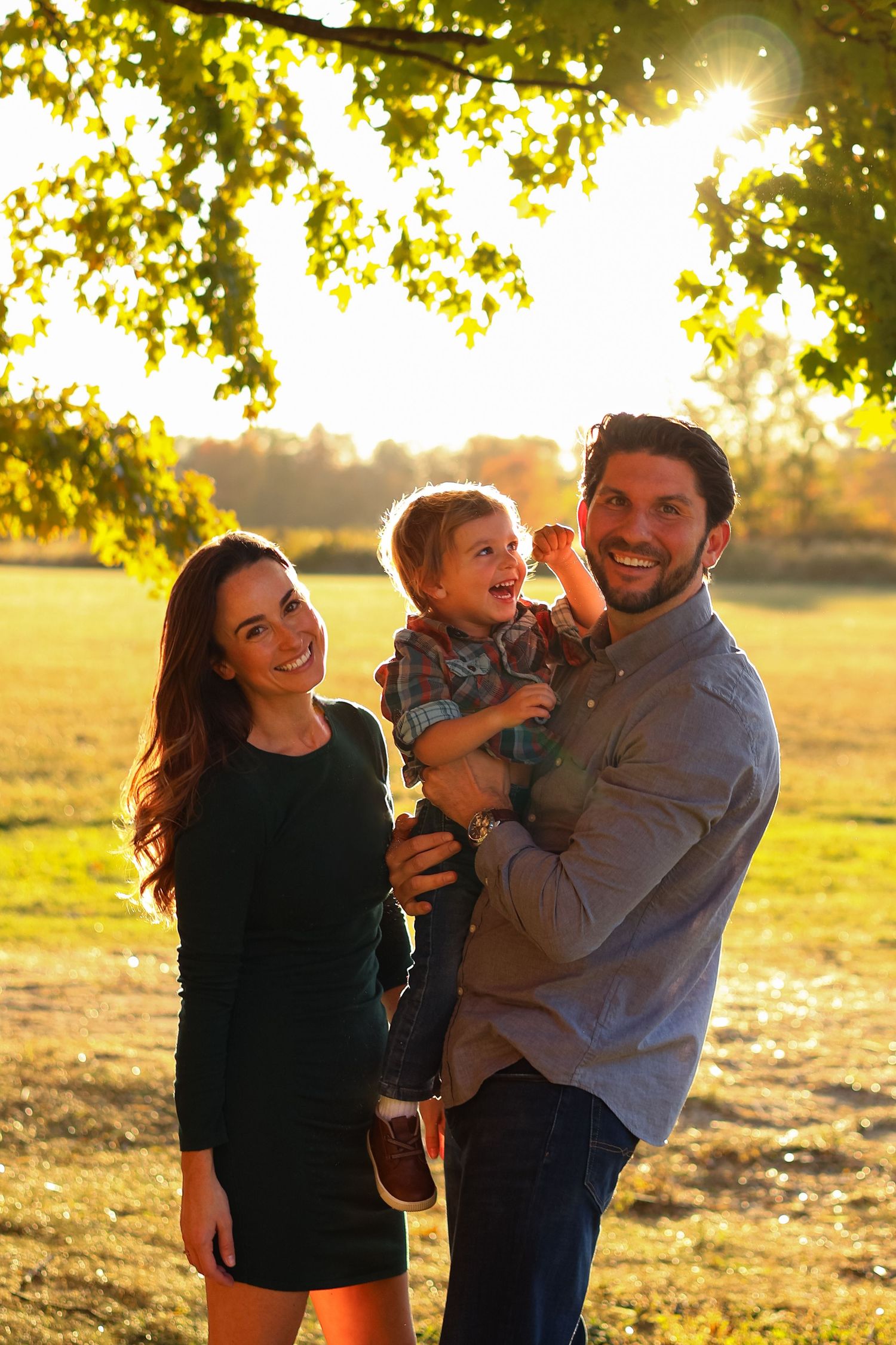 Family shares playful moments together in a sunny autumn field in Wilmington, Delaware.