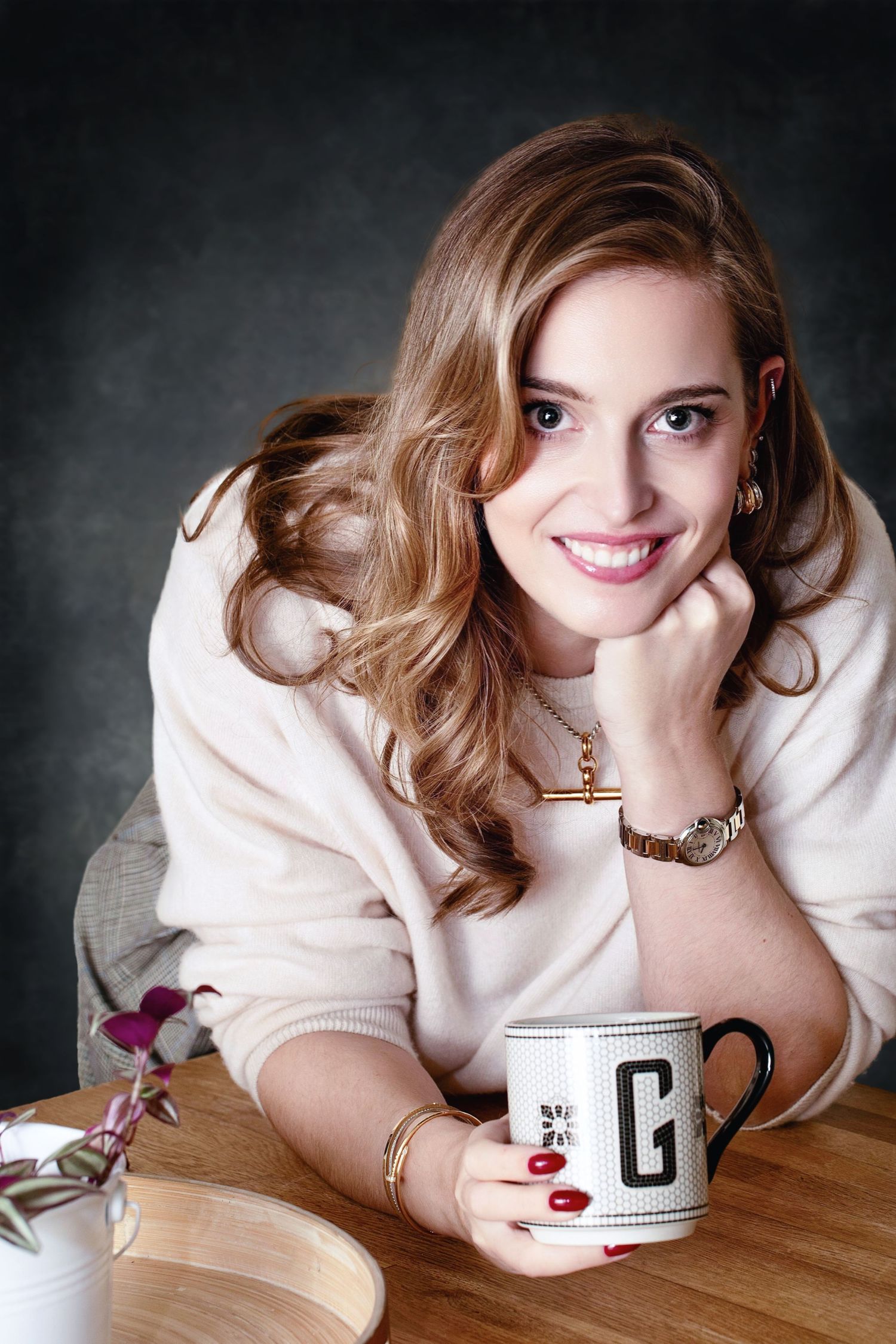 A series of cozy photos showing someone in a white sweater relaxing with a coffee cup on a wooden surface.
