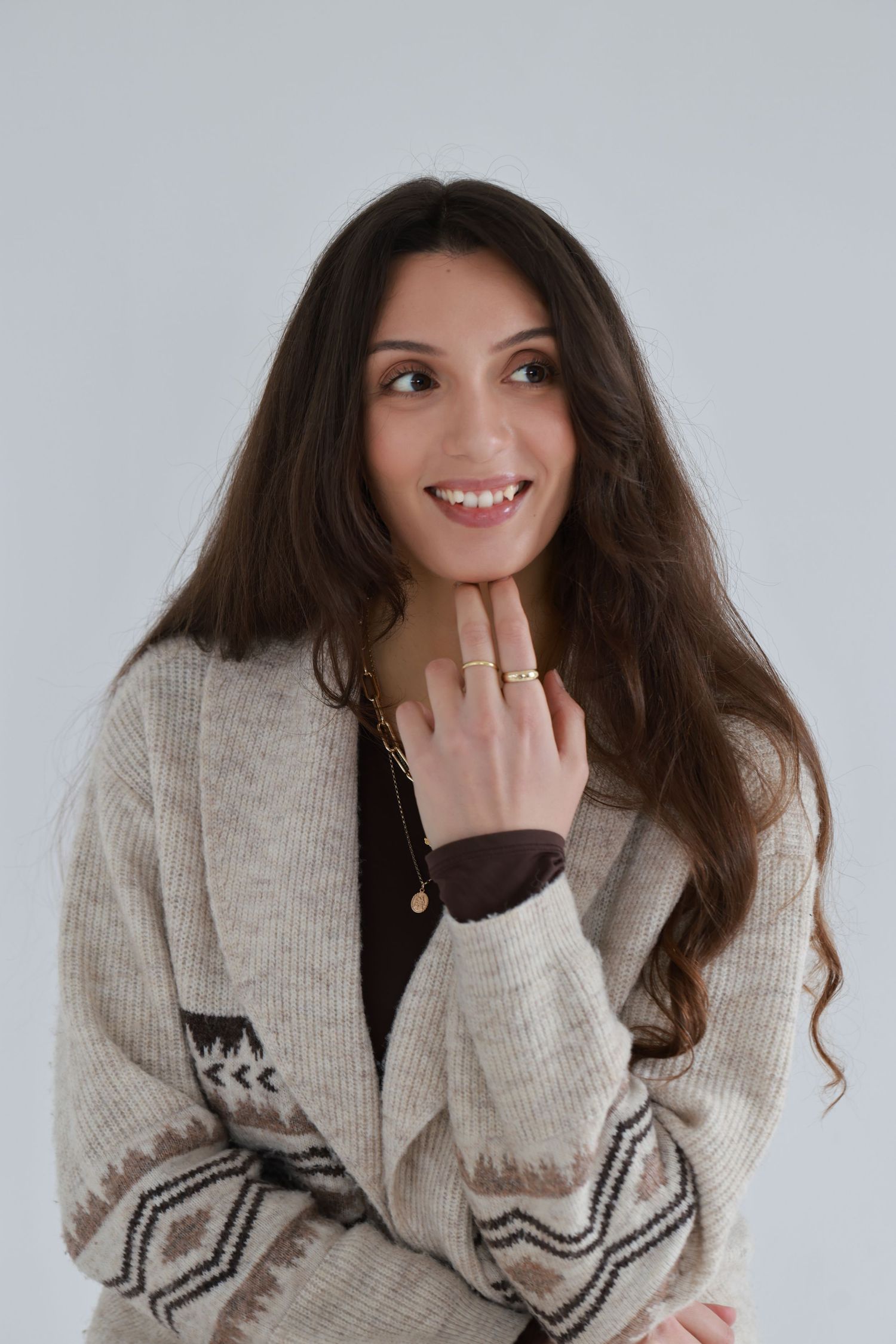 A person in a cozy beige knit sweater shows playful expressions in a series of connected photos.