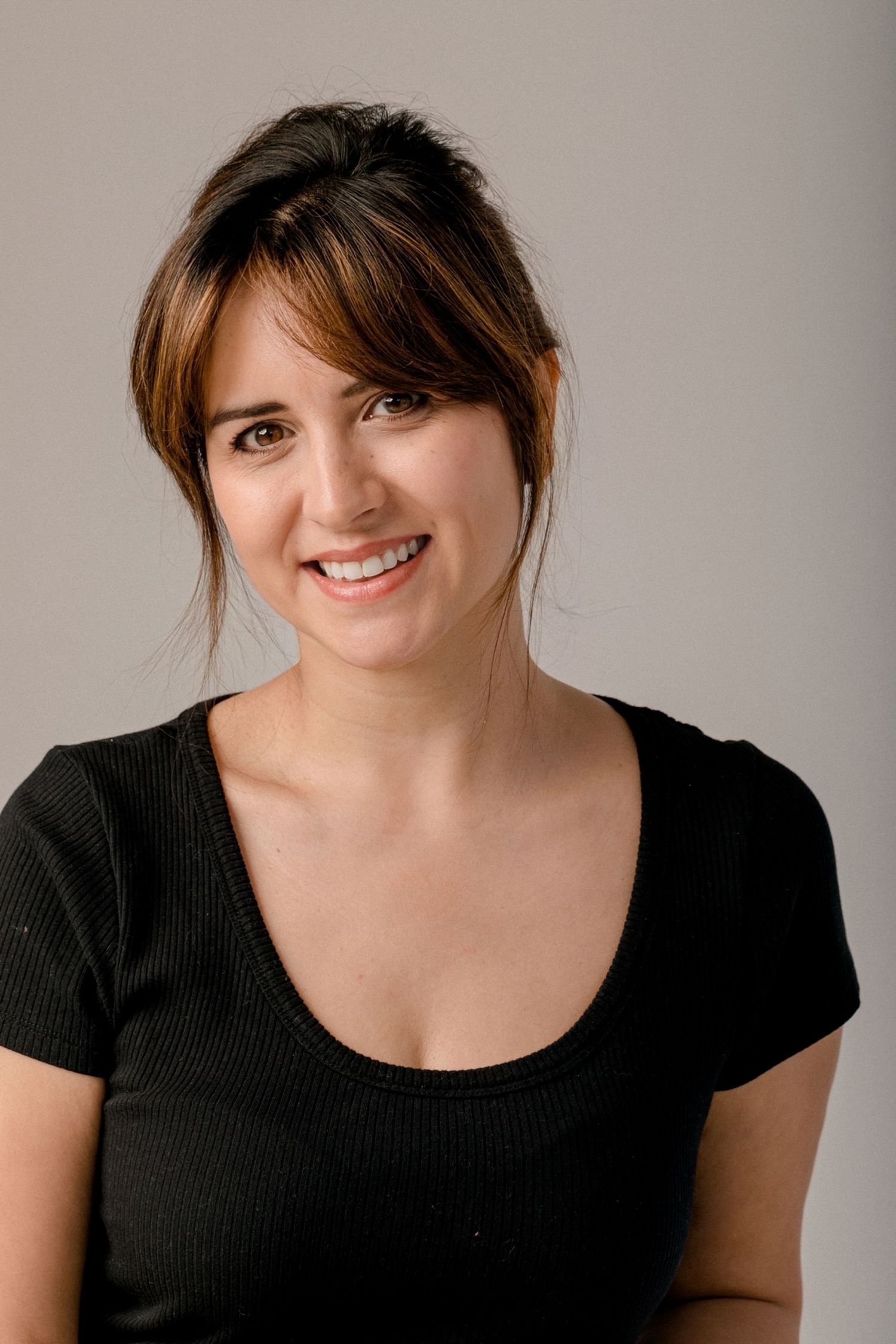 Portrait series showing four expressions in black top against neutral background.