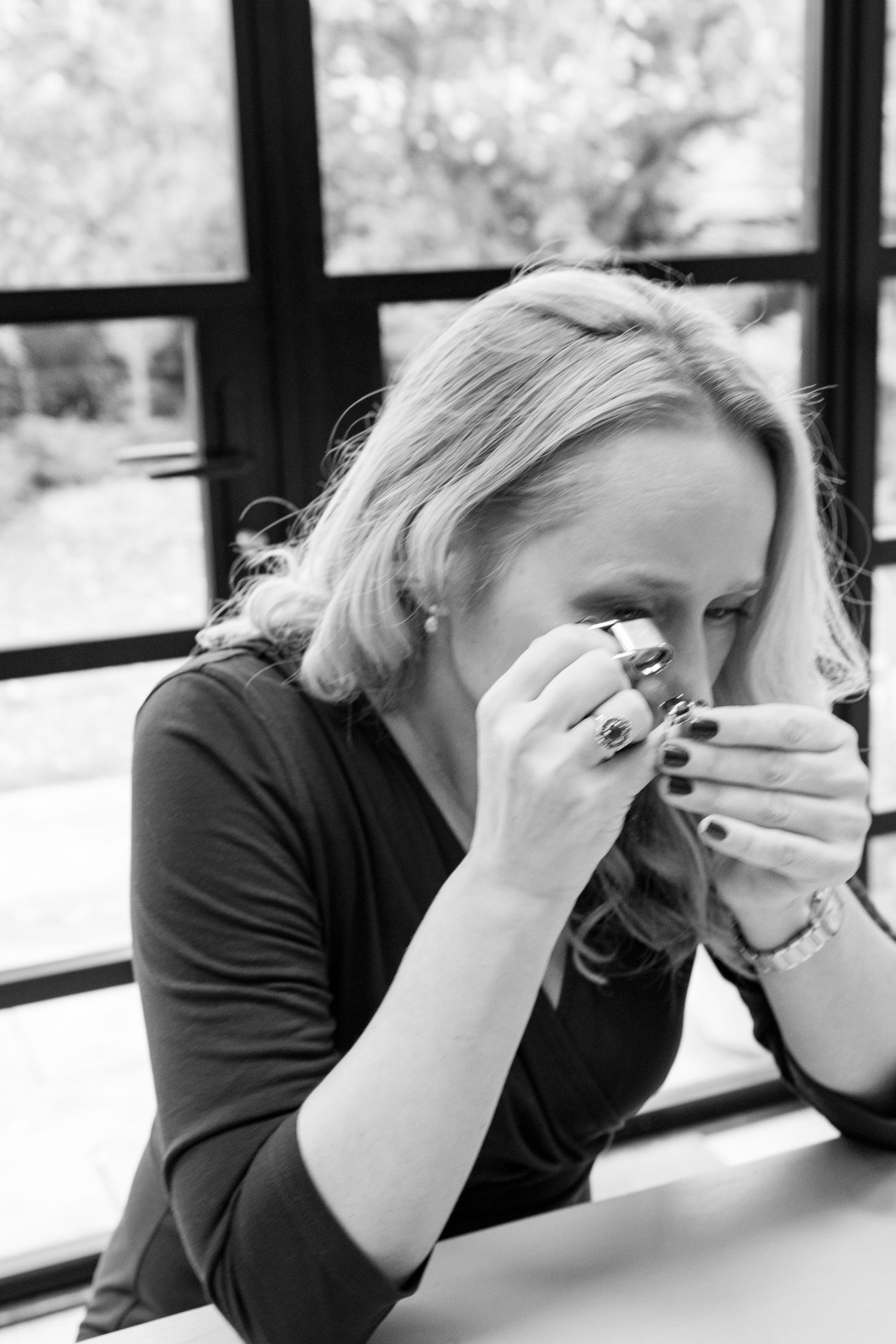 A series of black and white photos showing a person in a black shirt expressing distress while sitting by a window.