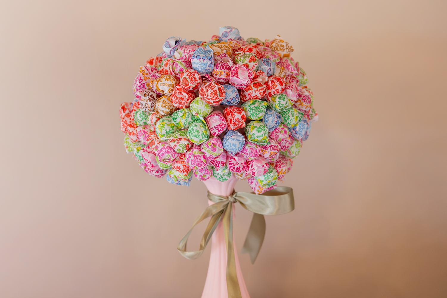 Colorful lollipop bouquet arrangement with pink and blue candy tied with a bow.